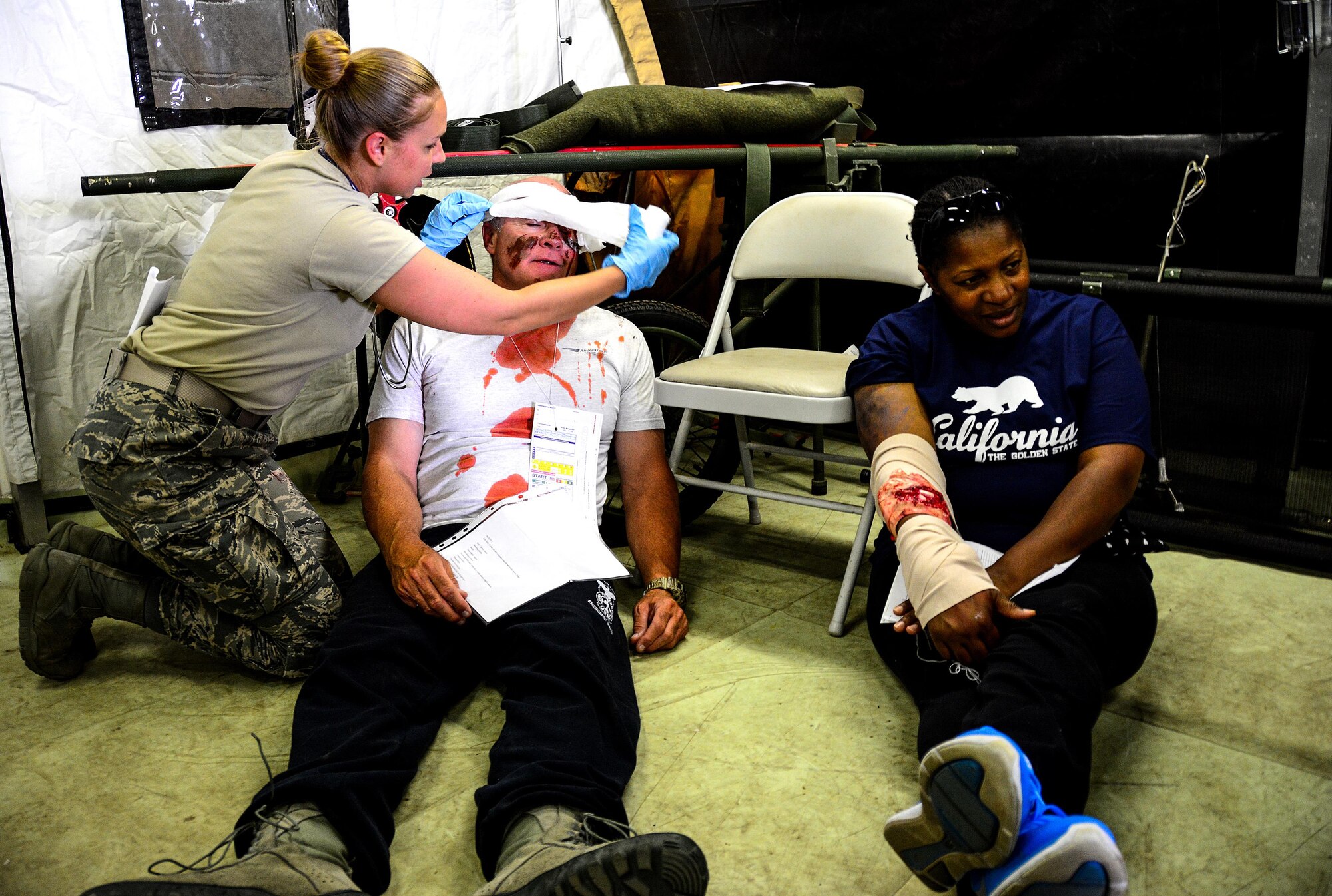 Senior Airman Savannah Johnson, 349th Aeromedical Squadron medical technicians, treats moulaged patients Staff Sgts. Rickey Popplewell and Veronia Knight, 129th Medical Group medical technicians, during a mass casualty exercise at Travis Air Force Base, Calif., on May 19, 2017. The 349th MDG conducted a week-long training session for medical Airmen that culminated in a mass casulaty training scenario. (U.S. Air Force photo/Staff Sgt. Daniel Phelps)