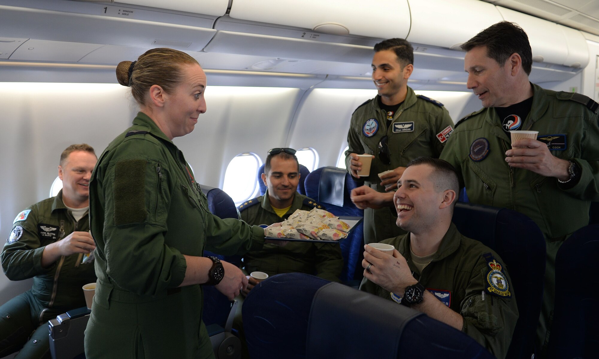 Royal Air Force Cpl. Niki Hargreaves, 10th Squadron cabin supervisor, serves snacks and drinks to the visiting crew on the Royal Air Force A330 Voyager during the European Tanker Symposium May 11, 2017, over England.  Pilots from different NATO countries went on board the Voyager to observe the mixed tanker formation. This was the first time two tankers from different countries took off from the same base in a mixed formation. (U.S. Air Force photo by Airman 1st Class Luke Milano)