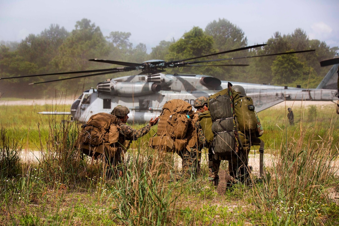 Two U.S. Marines and a Dutch marine prepare to board a CH-53 Super Stallion helicopter during an insertion and extraction drill as part of exercise Burmese Chase at Camp Lejeune, N.C., May 16, 2017. Marine Corps photo by Pfc. Taylor W. Cooper