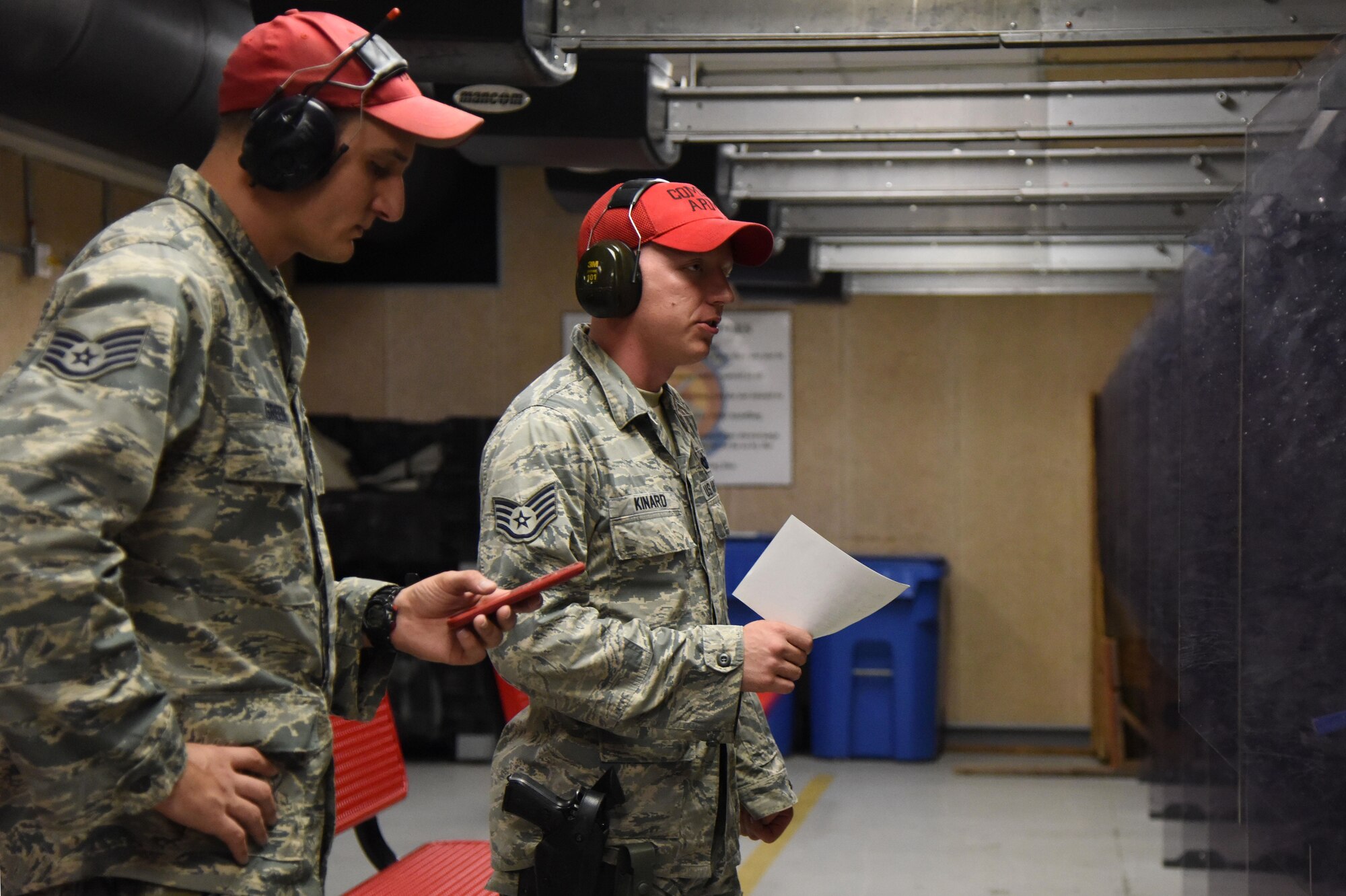 Staff Sgt. Joshua Green, 81st Security Forces Squadron combat arms instructor, operates the timer while Staff Sgt. Jarrod Kinard, 81st SFS combat arms NCOIC, reads the rules to competitors during the 81st SFS law enforcement team competition shoot in the indoor firing range May 17, 2017, on Keesler Air Force Base, Miss. The event was held during National Police Week, which recognizes the service of law enforcement men and women who put their lives at risk every day. (U.S. Air Force photo by Kemberly Groue)