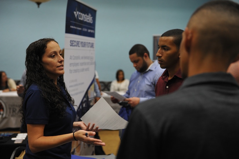 Amanda Lupton, recruiter for Constellis, shares company information with attendees during Hiring Our Heroes job fair held at the Community Club on Fort Buchanan, May 18th.