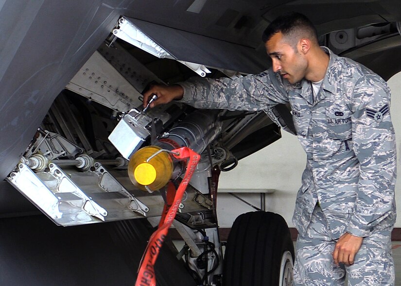 U.S. Air Force Senior Airman Christopher Lewis, 1st Maintenance Group weapons standardization lead crew member, finishes loading an AIM-9X missile onto an F-22 Raptor, at Joint Base Langley-Eustis, Va., April 19, 2017. The AIM-9X is a newer, more versatile weapon that was recently made compatible with the F-22. (U.S. Air Force photo/Airman 1st Class Amanda Dole)