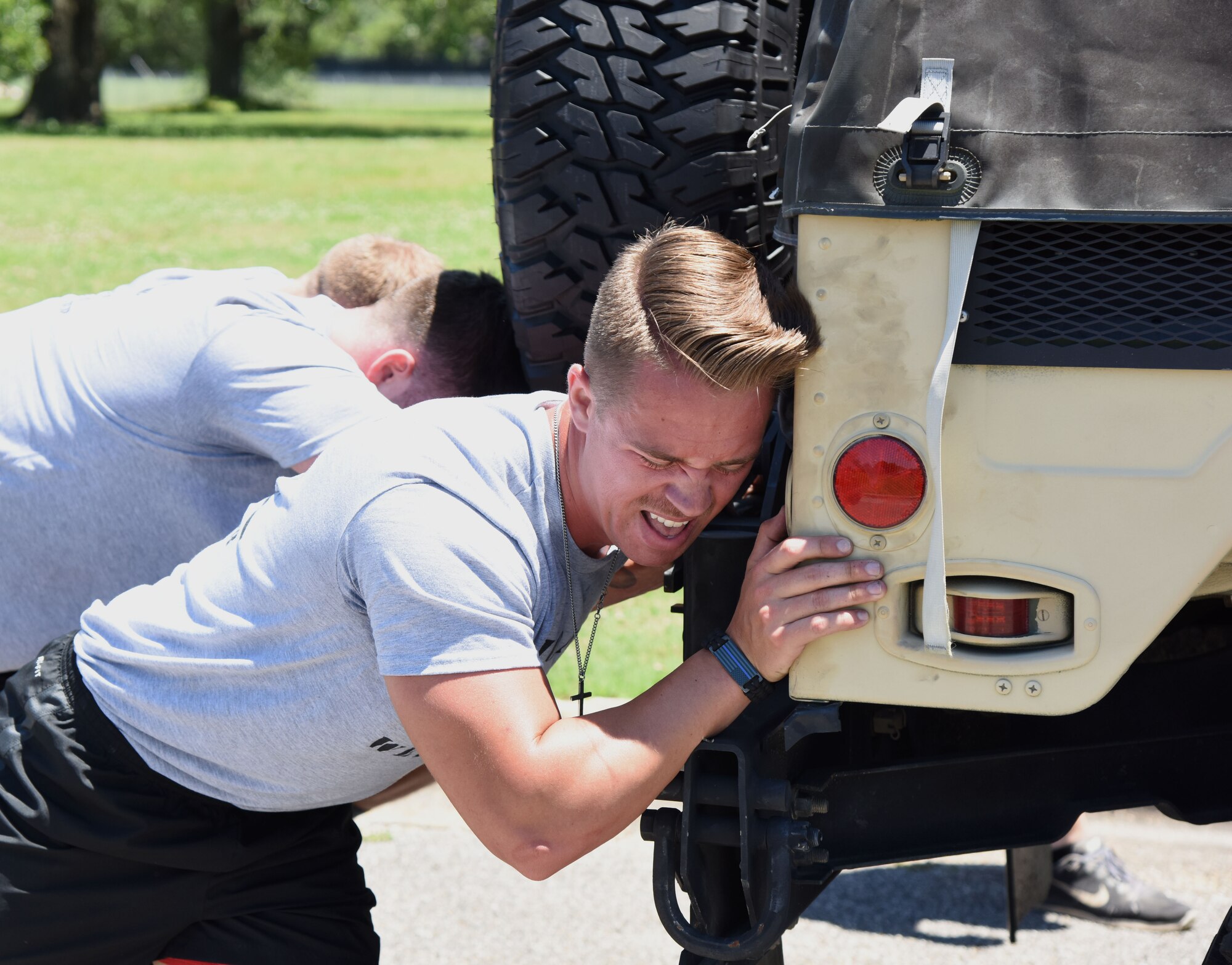 Staff Sgt. Caleb Gilliard, 81st Security Forces Squadron combat arms instructor, assists his team with pushing a Humvee during the 81st Security Forces Squadron obstacle course competition May 16, 2017, on Keesler Air Force Base, Miss. The competition was held during National Police Week, which recognizes the service of law enforcement men and women. (U.S. Air Force photo by Kemberly Groue)