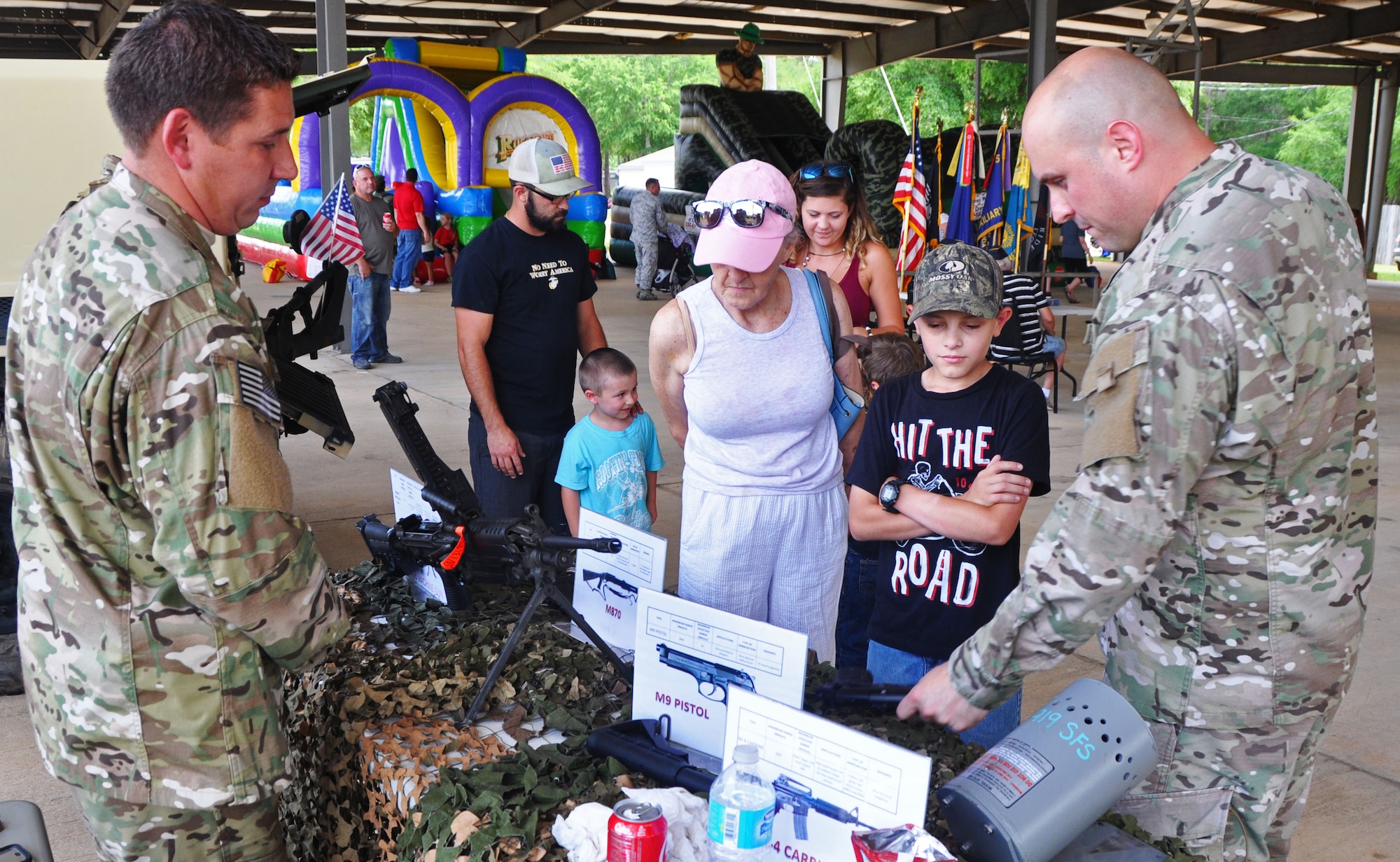 Tech. Sgt. Jonathan Inabnet and Staff Sgt. Brian Ploof, 919th Special Operations Security Forces Squadron, educate visitors about their weapons display at the Military Appreciation Recognition Celebration in Crestview, Fla., May 20, 2017. The annual event affords a unique opportunity for Crestview area citizens to meet military members and thank them for their service in national defense. (U.S. Air Force photo/Dan Neely)