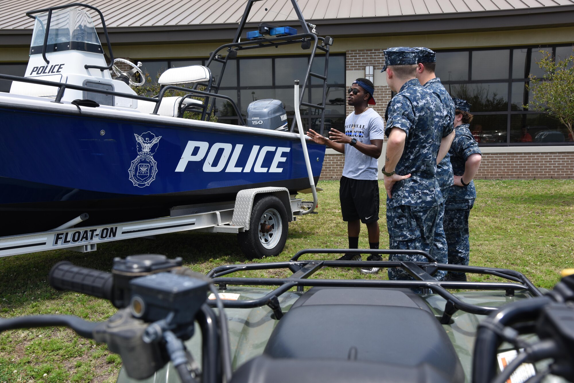 Airman 1st Class Lionel Jones, 81st Security Forces Squadron entry controller, briefs members of the Center For Naval Aviation Technical Training Unit Keesler on the 81st SFS boating mission during Police Week fun day at the Base Exchange May 18, 2017, on Keesler Air Force Base, Miss. The event was held during National Police Week, which recognizes the service of law enforcement men and women who put their lives at risk every day. (U.S. Air Force photo by Kemberly Groue)