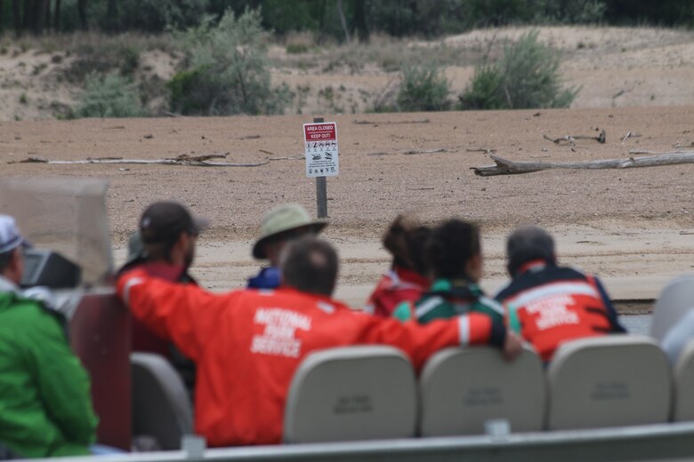 Members and support staff of the Missouri River Recovery Implementation Committee view sandbar habitat for the interior least turn and piping plover on the Missouri River.  Signs are posted during nesting season to alert people on the river to the presence of nesting birds in order to protect the nests from accidental damage. 