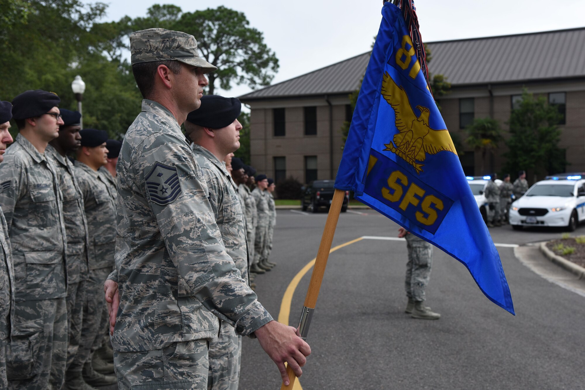 Master Sgt. Jason Burdett, 81st Security Forces Squadron first sergeant, holds the guidon while standing in formation during the 81st SFS retreat ceremony May 18, 2017, on Keesler Air Force Base, Miss. The event was held during National Police Week, which recognizes the service of law enforcement men and women who put their lives at risk every day. (U.S. Air Force photo by Kemberly Groue)