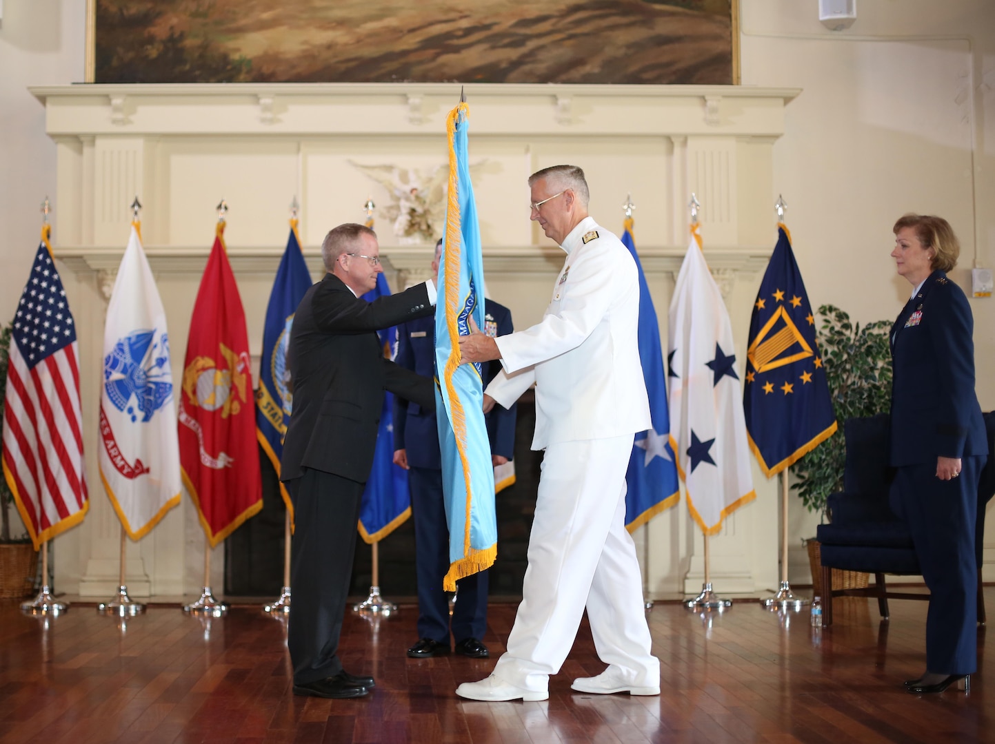 Navy Vice Adm. David H. Lewis receives the Defense Contract Management Agency flag from James MacStravic, performing the duties of  undersecretary of defense for acquisition, technology and logistics, at a May 24 change of command ceremony at Fort Lee, Virginia. Lewis relieves Air Force Lt. Gen. Wendy Masiello as director of Fort Lee-headquartered DCMA and its 12,000 acquisition professionals working out of offices and production
facilities around the world. (DCMA photo by Stephen Hickok)  
