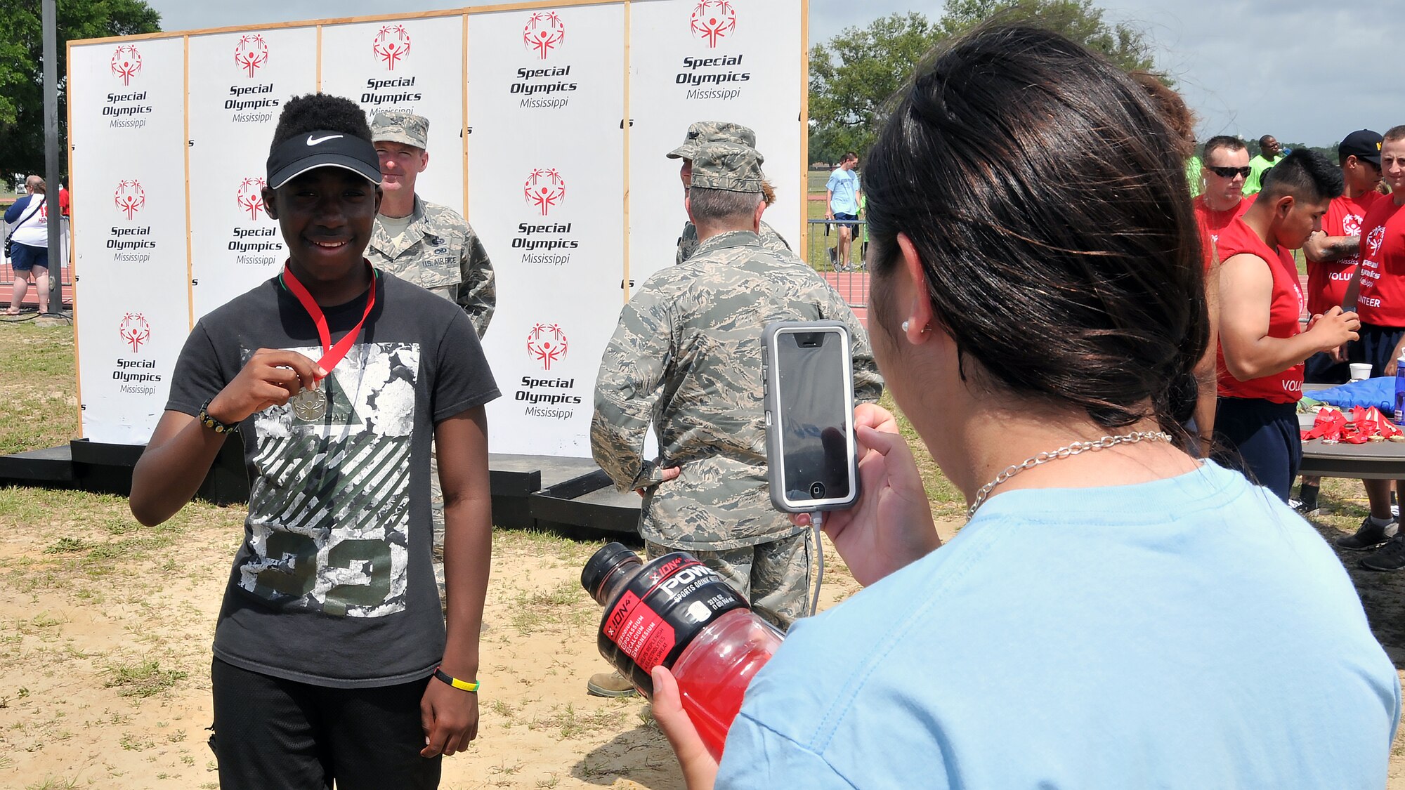 Airman 1st Class Sierra Ward, 335th Training Squadron personnel student, takes a picture of Nicholas Berry, a Special Olympics athlete, during the Special Olympics Mississippi 2017 Summer Games May 20, 2017, on Keesler Air Force Base, Miss. Berry earned a gold medal in the standing long jump event and a silver medal in the 200-meter dash. (U.S. Air Force photo by Senior Airman Jenay Randolph)
