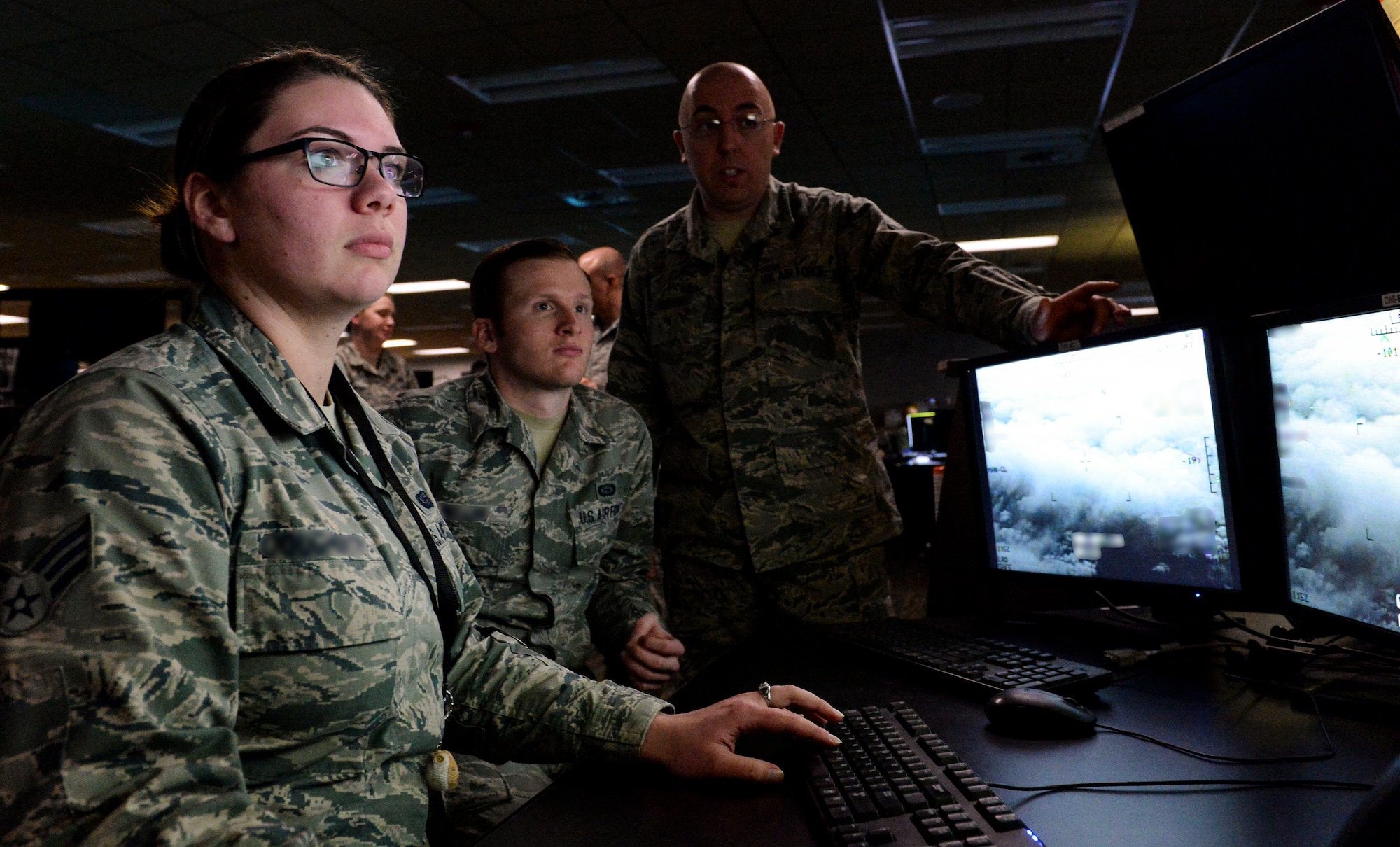 Airmen from the 480th Intelligence, Surveillance and Reconnaissance Wing perform their jobs at Joint Base Langley-Eustis, Virginia. An Airmen Resiliency Team stays embedded with the 480th ISR Wing during the COVID-19 pandemic to provide mental, medical and spiritual care to help Airmen cope with their high stress duties. (U.S. Air Force photo by Senior Airman Nicholas Byers) (This photo has been altered for security purposes by blurring out identification badges)