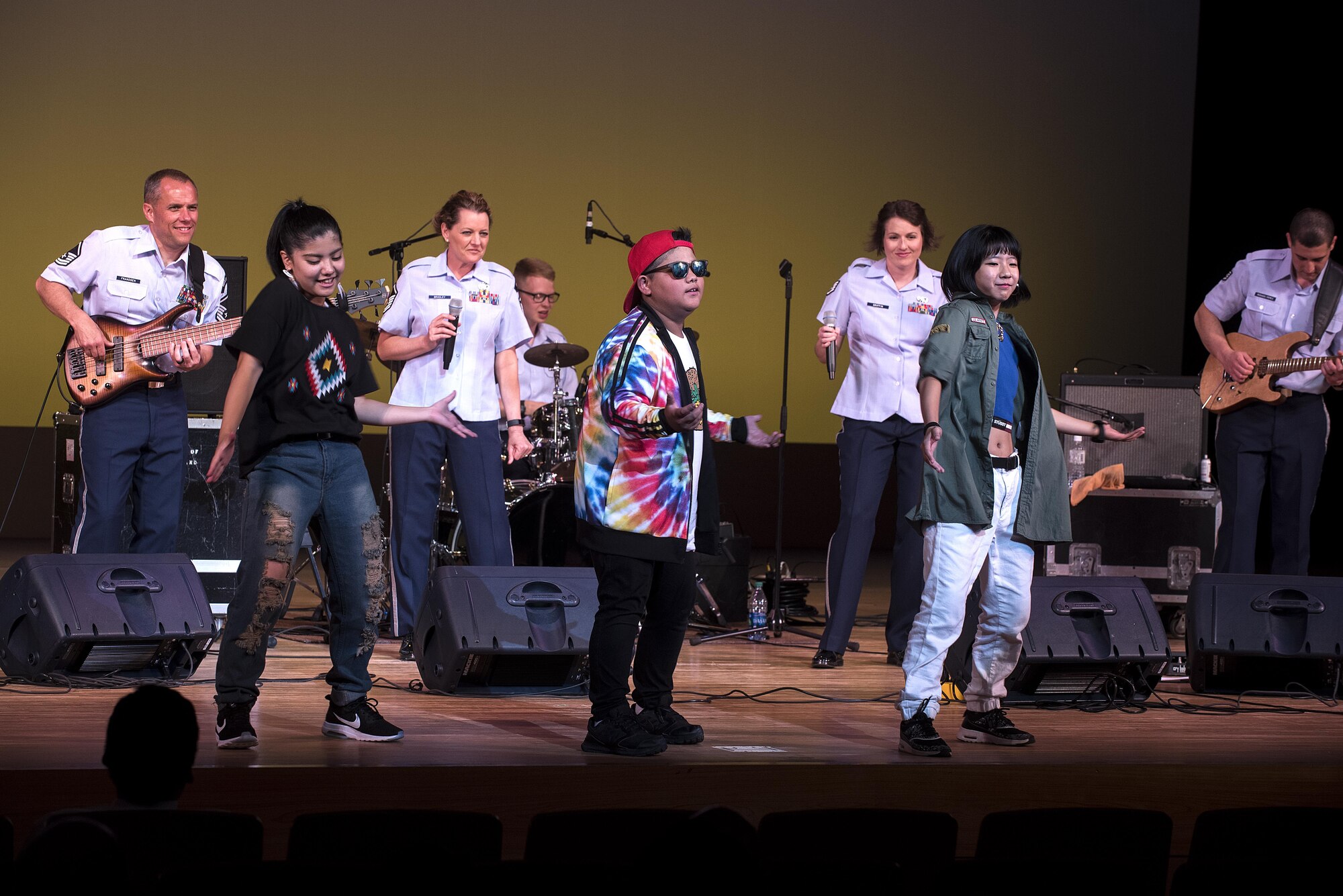 Okinawan jr. high school students dance on stage with members of the U.S. Air Force Band of the Pacific-Asia at the Pacific Trends concert in Tedako Hall in Urazoe City, Japan, May 24, 2017. The students performed a choreographed routine as the band played the song “Happy.” (U.S. Air Force photo by Senior Airman Corey Pettis)
