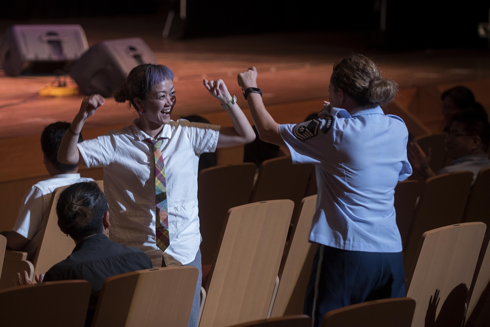 U.S. Air Force Master Sgt. Julie Bradley, U.S. Air Force Band of the Pacific-Asia, Pacific Trends singer, dances with an audience member during a concert at Tedako Hall in Urazoe City, Japan, May 24, 2017. The Air Force band of the Pacific travels throughout the Indo-Asia Pacific region performing concerts for community relations events. (U.S. Air Force photo by Senior Airman Corey Pettis)