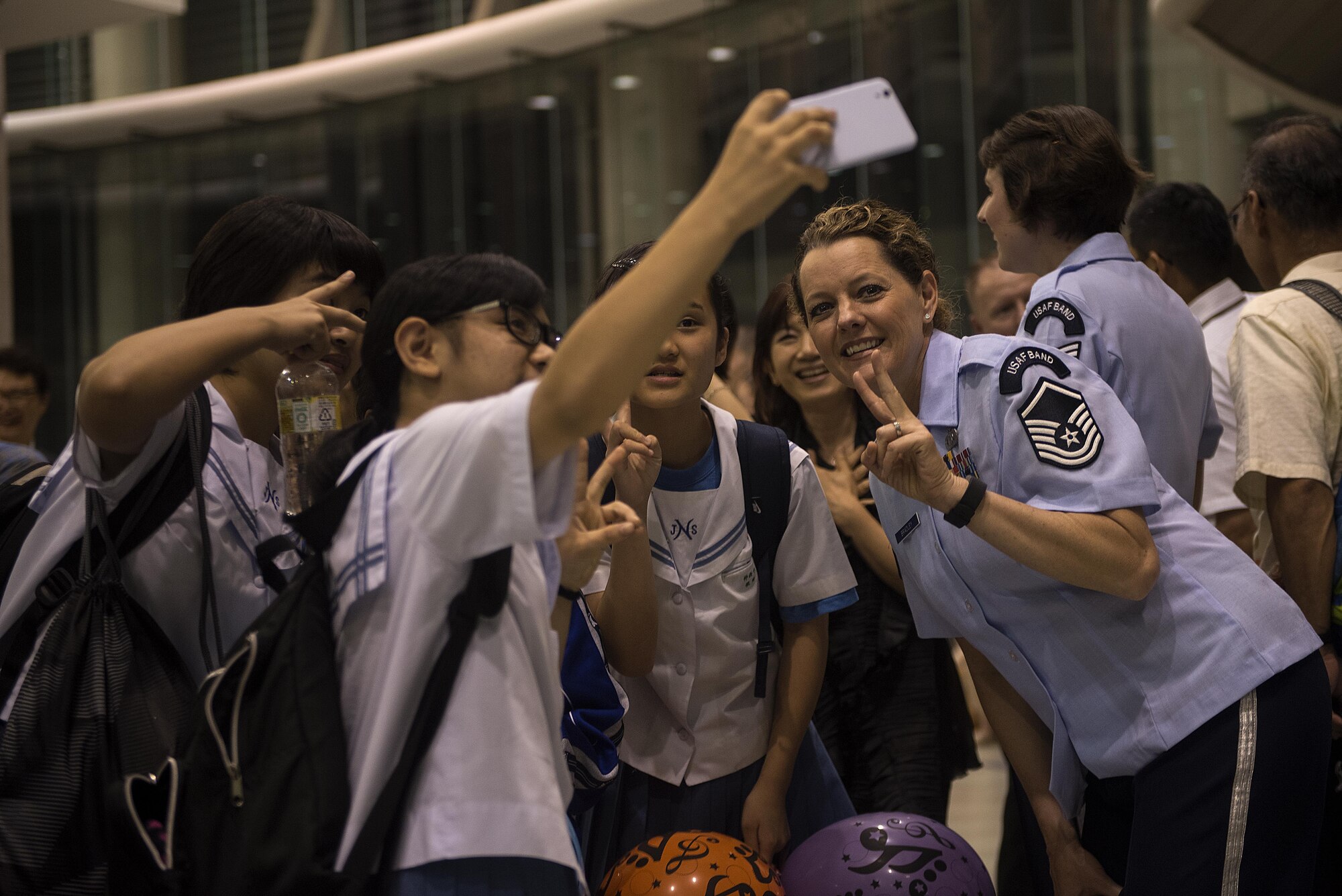 U.S. Air Force Master Sgt. Julie Bradley, U.S. Air Force Band of the Pacific-Asia, Pacific Trends singer, takes a picture with fans after a concert at Tedako Hall in Urazoe City, Japan, May 24, 2017. After performing two hours’ worth of popular American and Japanese rock songs, the band members met and took pictures with audience members. (U.S. Air Force photo by Senior Airman Corey Pettis)
