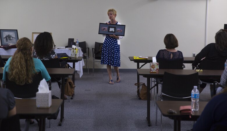 Linda Sanborn, wife of Maj. Gen. Russell A. Sanborn, the commanding general of 1st Marine Aircraft Wing, III Marine Expeditionary Force, shares her story with military spouses, at Camp Foster, Okinawa, Japan, May 23, 2017, by showing photos of her husband’s aircraft, which was shot down during Operation Desert Storm in 1991. While sharing her story, Linda described the Marine Corps as a family that will be there during a times of need. She is a native of DeLand, Florida. (U.S. Marine Corps photo by Lance Cpl. Andy Martinez)