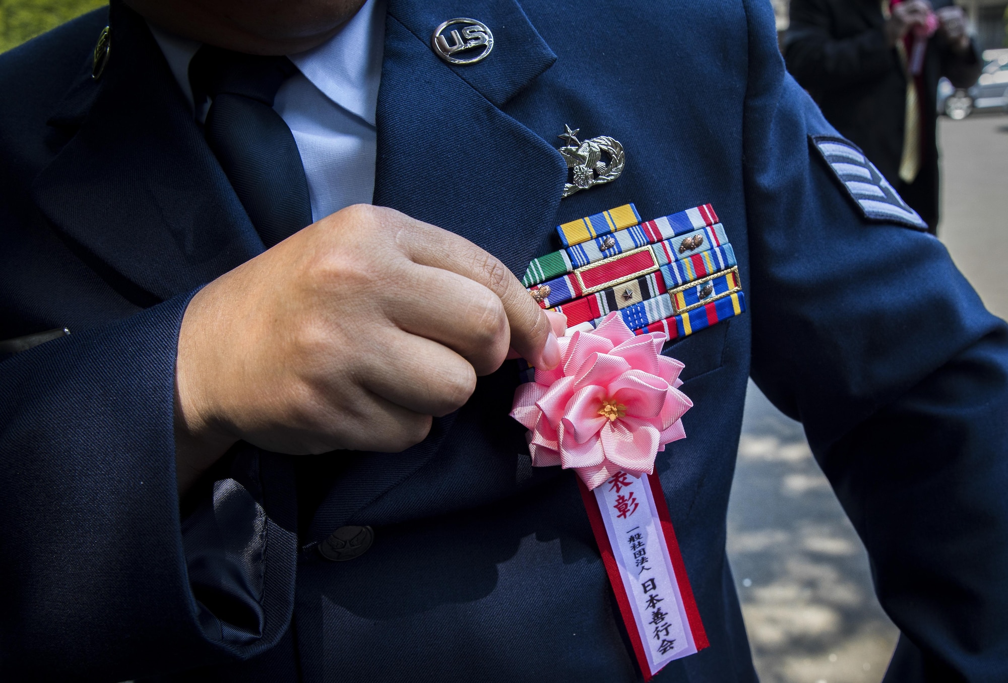 An Airman assigned to the 374th Airlift Wing adjusts his award decoration badge before the Good Deed Award Ceremony, May 20, 2017, at the Meiji Shrine, Tokyo, Japan. Five groups from Yokota Air Base received this year’s award by doing various acts of social welfare support, guidance of youths and children, contribution to public life, and good neighborhood programs.  (U.S. Air Force photo by Airman 1st Class Donald Hudson)