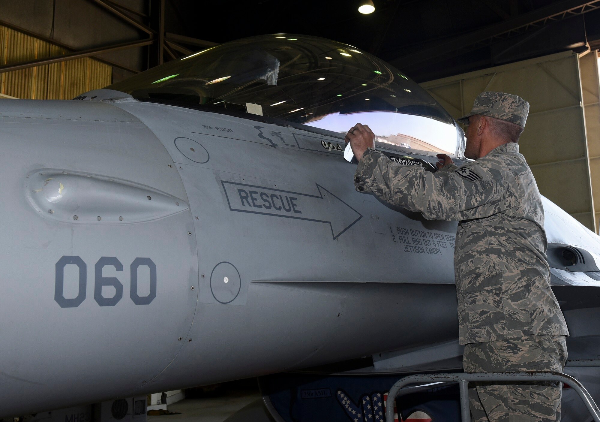 U.S. Air Force Staff Sgt. Shane McGowen, 35th Aircraft Maintenance Unit F-16 Fighting Falcon crew chief, reveals the name of Col. David Shoemaker, 8th Fighter Wing commander, on a jet during a change of command ceremony at Kunsan Air Base, Republic of Korea, May 25, 2017. Kunsan hosted a change of command ceremony, in which Col. Todd Dozier relinquished command of the 8th Fighter Wing to Col. David Shoemaker. (U.S. Air Force photo by Senior Airman Michael Hunsaker/Released)