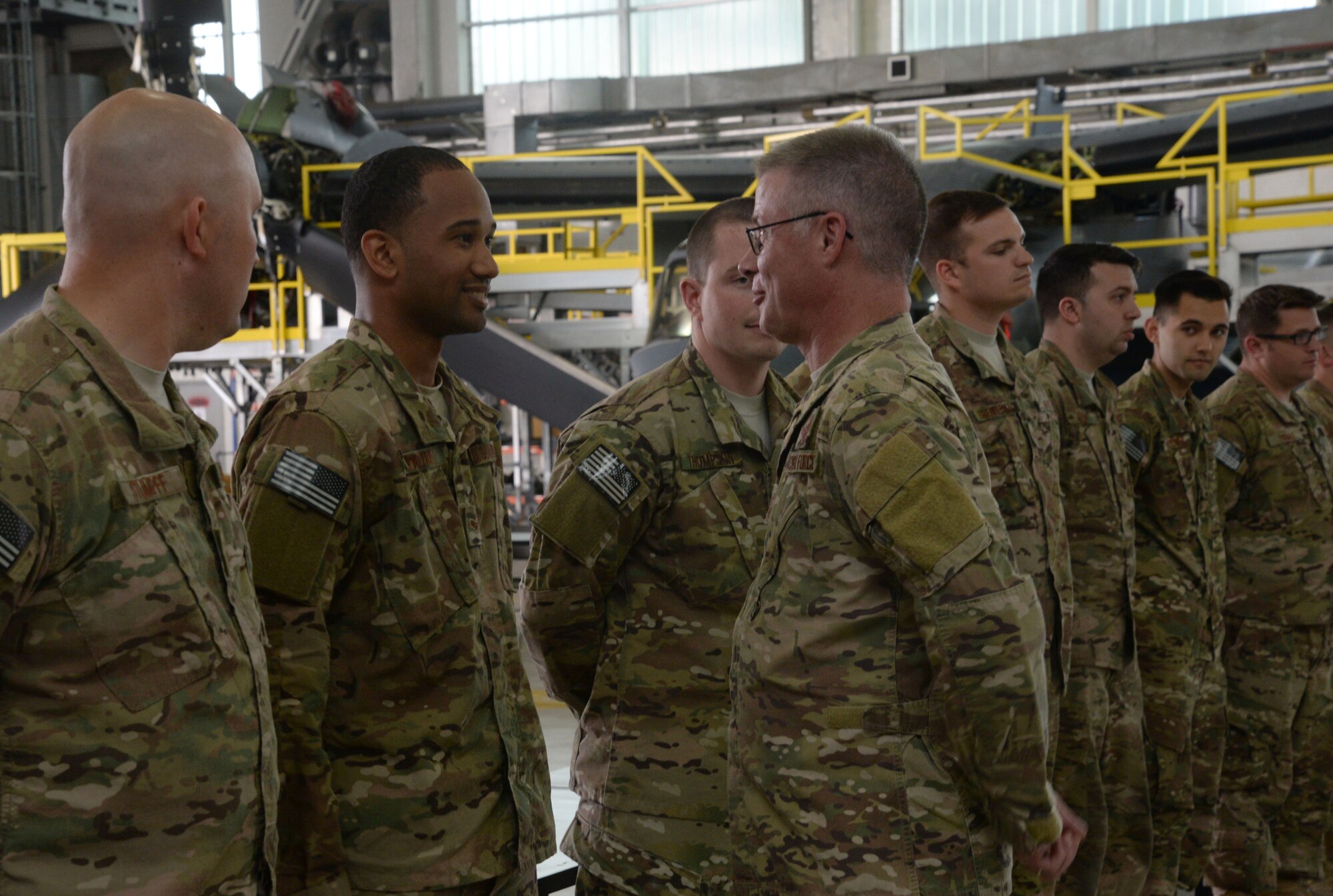 U.S. Air Force Chief Master Sgt. Gregory Smith, Command Chief Master Sergeant of Air Force Special Operations Command, center, greets a line of Airmen assigned to the 352nd Special Operations Maintenance Squadron, May 24, 2017, during his visit to RAF Mildenhall, England. Smith coined outstanding Airmen and expressed gratitude to the unit for their dedication to the mission. (U.S. Air Force photo by Senior Airman Justine Rho)