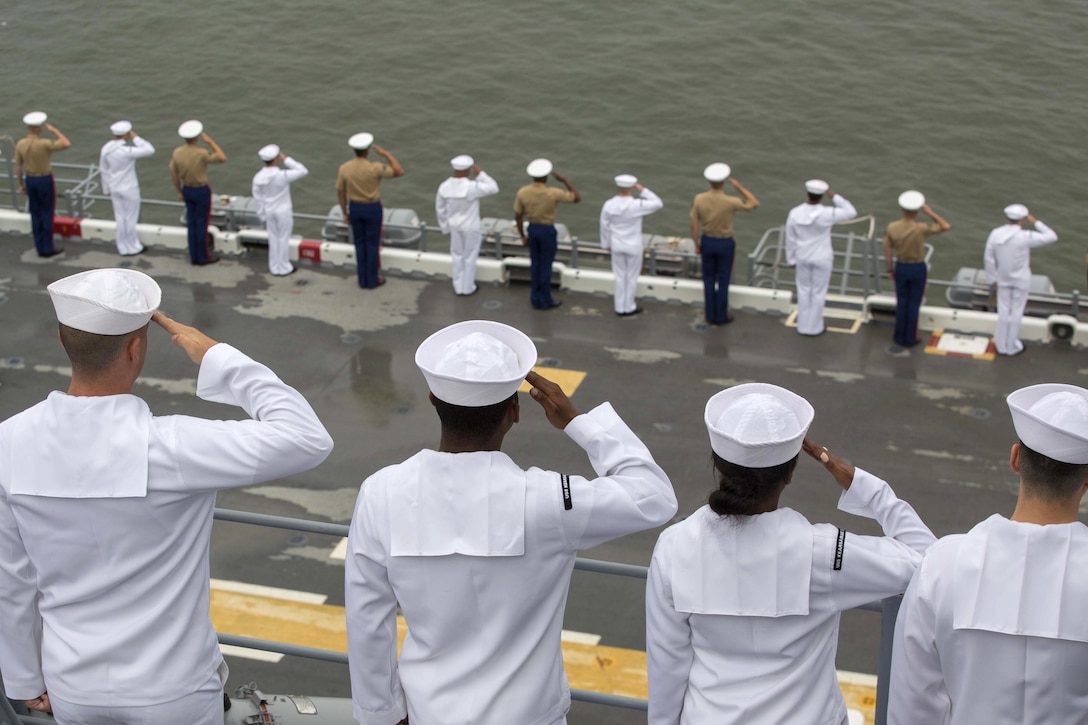 Marines and sailors salute as their ship passes a national monument during the parade of ships as part of Fleet Week New York in New York City, May 24, 2017. Marine Corps photo by Pfc. Abrey D. Liggins