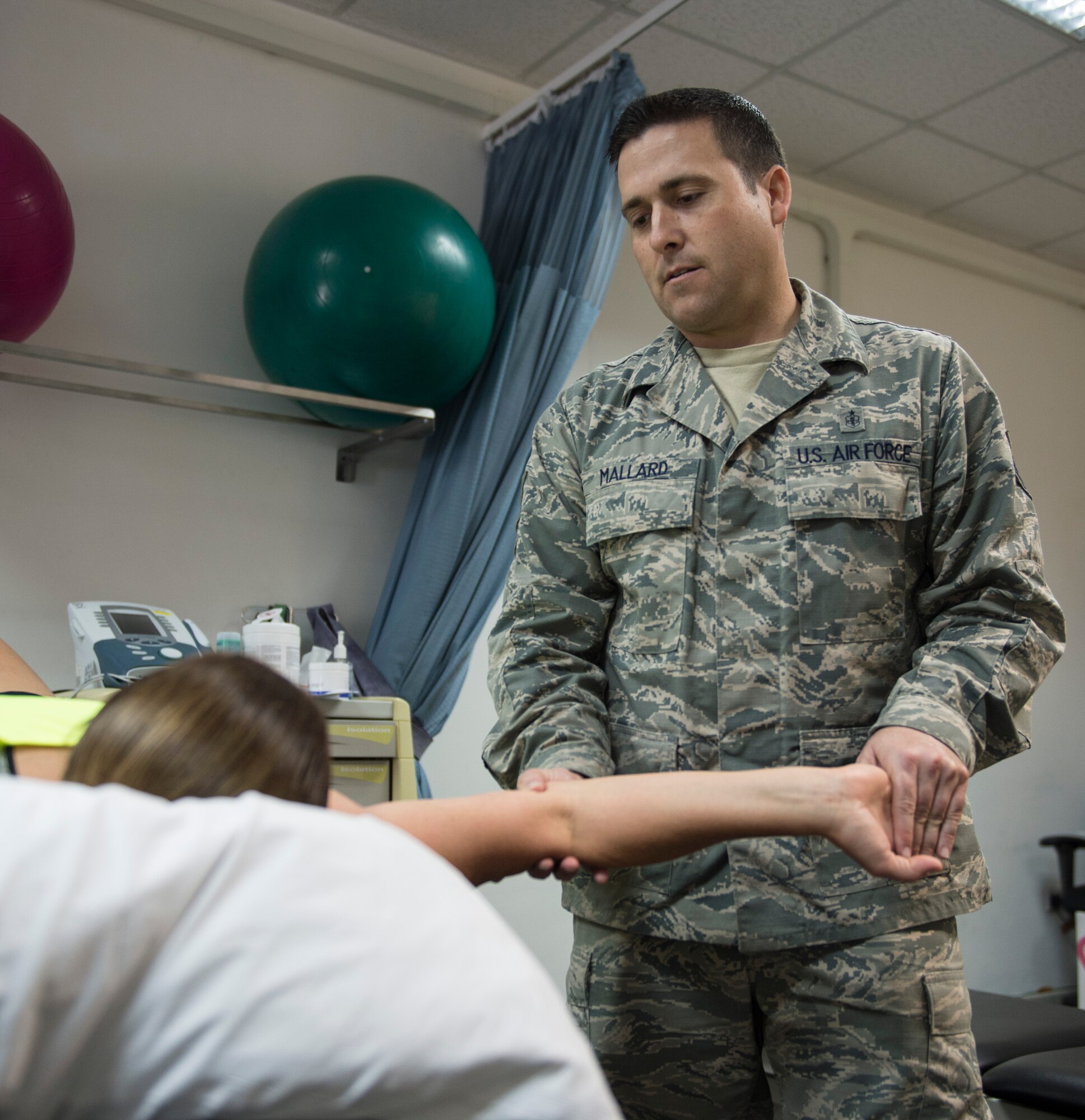 U.S. Air Force Tech. Sgt. James Mallard, physical medicine technician, flight chief of ancillary operations with the 379th Expeditionary Medical Operations, stretches a patient’s arm at Al Udeid Air Base, Qatar, May 15, 2017. Airmen assigned to the physical therapy element help other service members regain full mobility from an injury and experience relief from pain. (U.S. Air Force photo by Tech. Sgt. Amy M. Lovgren)