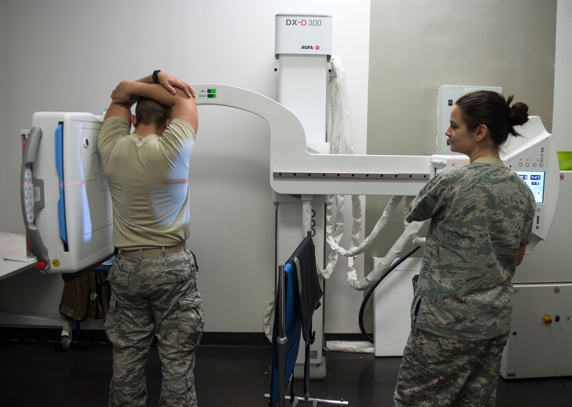 U.S. Air Force Staff Sgt. Jessica Corley, right, an x-ray and ultrasound technician with the 379th Expeditionary Medical Operations Squadron, runs an x-ray test on an airman at Al Udeid Air Base, Qatar, May 15, 2017. The radiology program helps the primary care clinic with diagnosis of suspected injuries or internal injuries by using the x-ray machine or the CT scan of the body. (U.S. Air Force photo by Tech. Sgt. Amy M. Lovgren)