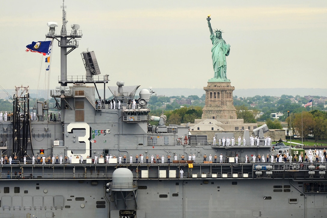 Sailors and Marines aboard the amphibious assault ship USS Kearsarge man the rail as the ship passes the Statue of Liberty during the parade of ships at the start of Fleet Week New York in New York, May 24, 2017. Navy photo by Chief Travis Simmons