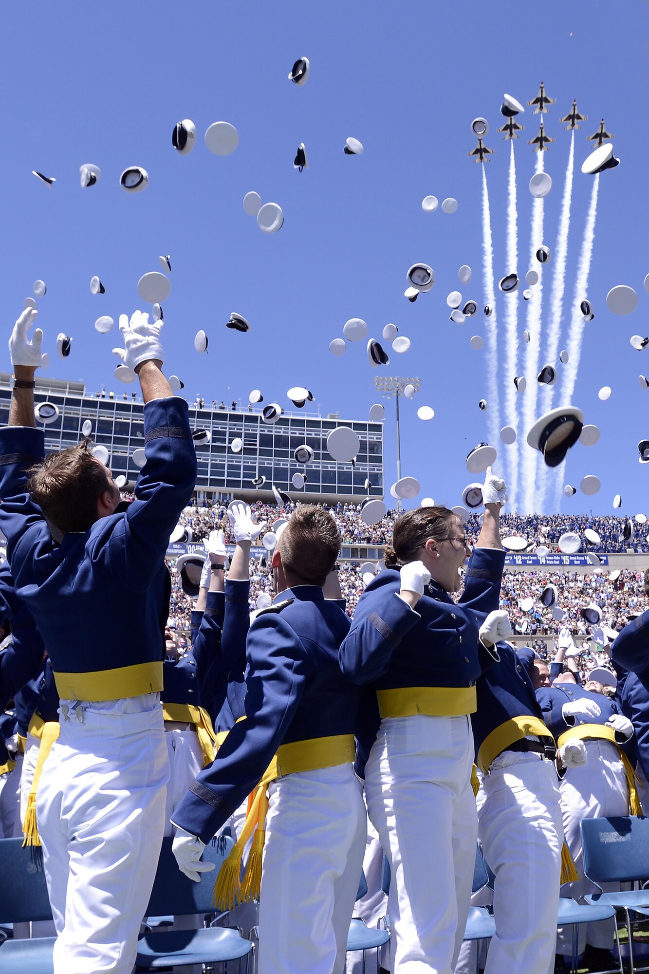 Newly-commissioned Air Force officers toss their hats in the air as the Air Force Thunderbirds fly over Falcon Stadium, May 24, 2017, at the end of the U.S. Air Force Academy's Class of 2017 graduation ceremony. (U.S. Air Force photo/Mike Kaplan)