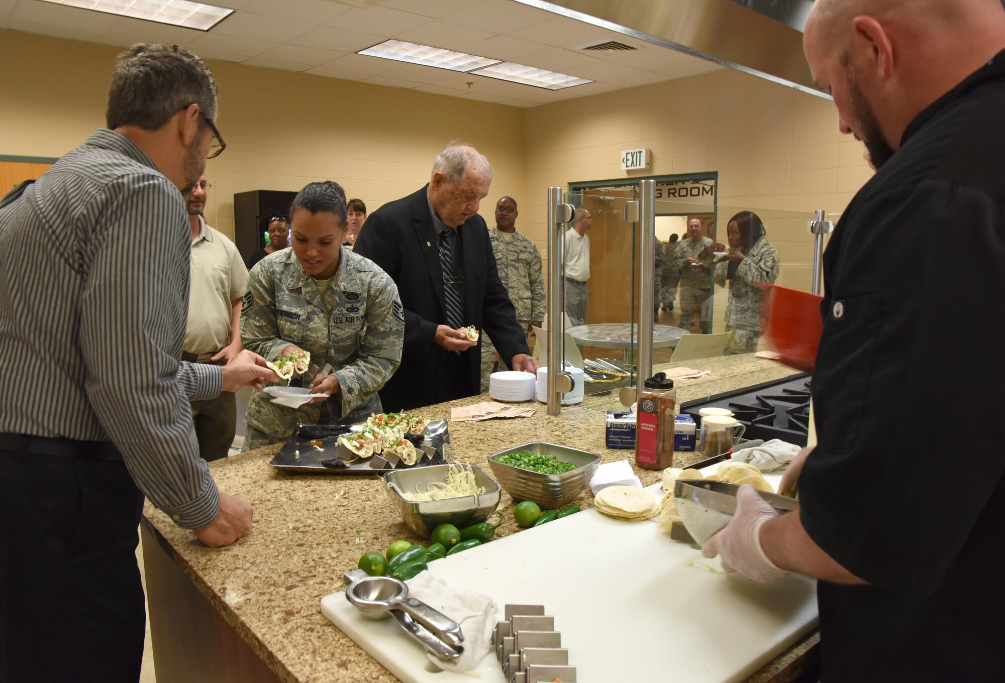 Keesler personnel sample food from a kitchen demo during the McBride Commons Grand Opening ceremony May 16, 2017, on Keesler Air Force Base, Miss. The nine-month project transformed the former base library into a common area with a children’s library, computer stations, engraving, framing, marketing and print shops and a full kitchen for those with base access. (U.S. Air Force photo by Kemberly Groue)