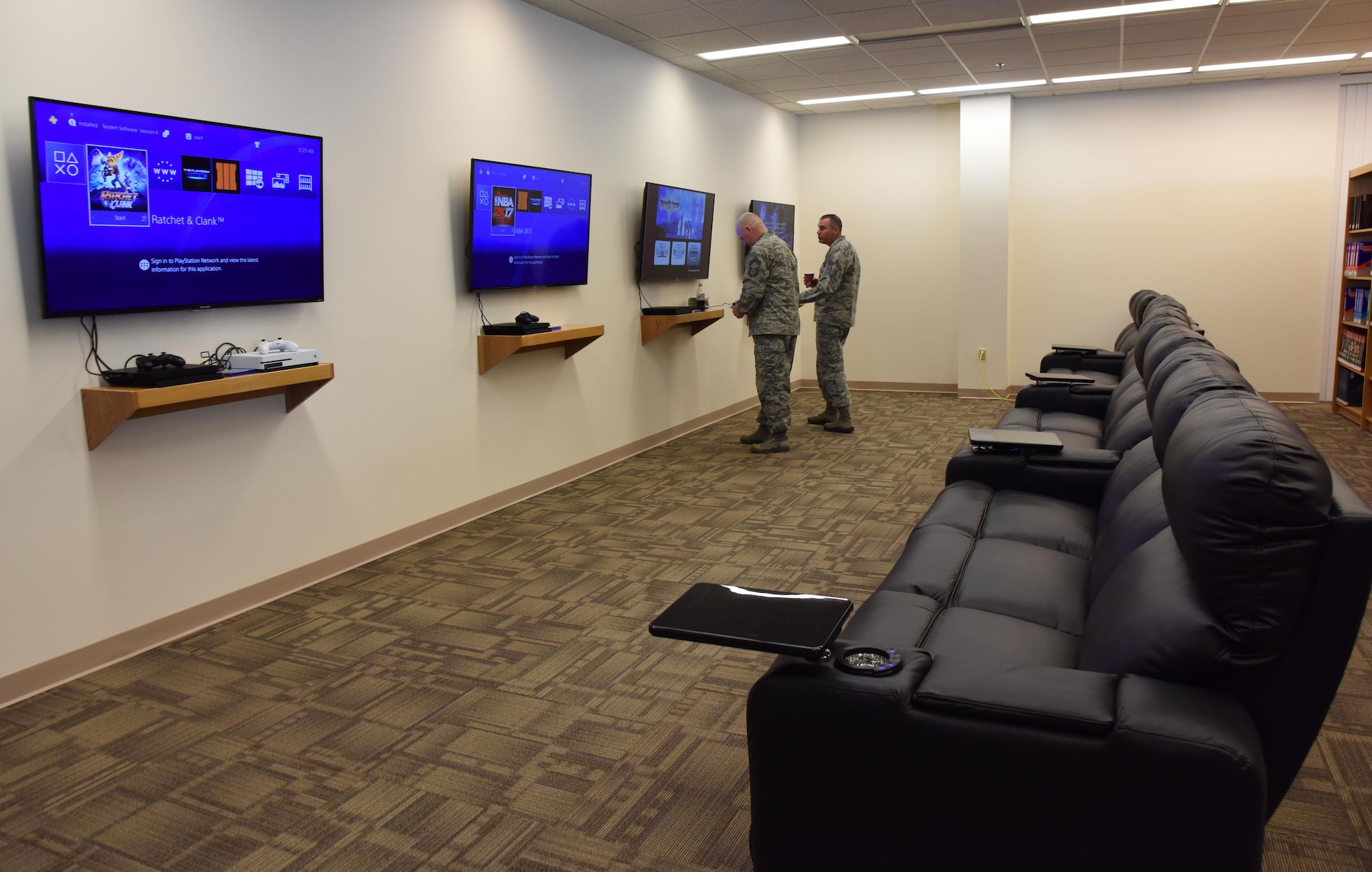 Chief Master Sgts. Derick Stepp, 81st Mission Support Group superintendent, and Leonard Trombley, 81st Training Support Squadron superintendent, check out the gaming station during the McBride Commons Grand Opening ceremony May 16, 2017, on Keesler Air Force Base, Miss. The nine-month project transformed the former base library into a common area with a children’s library, computer stations, engraving, framing, marketing and print shops and a full kitchen for those with base access. (U.S. Air Force photo by Kemberly Groue)