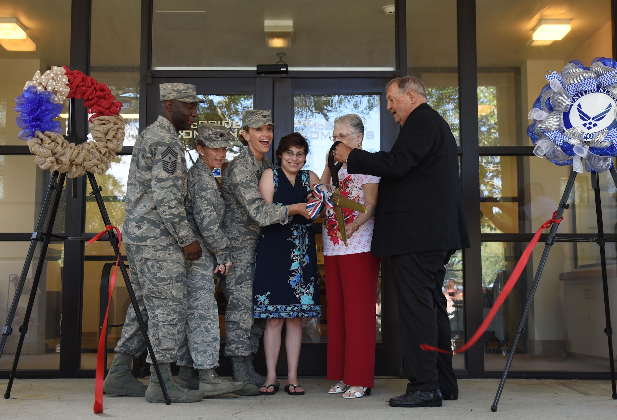 Keesler leadership and family members of Maj. Edward McBride participate in a ribbon cutting during the McBride Commons Grand Opening ceremony May 16, 2017, on Keesler Air Force Base, Miss. The nine-month project transformed the former base library into a common area with a children’s library, computer stations, engraving, framing, marketing and print shops and a full kitchen for those with base access. (U.S. Air Force photo by Kemberly Groue)