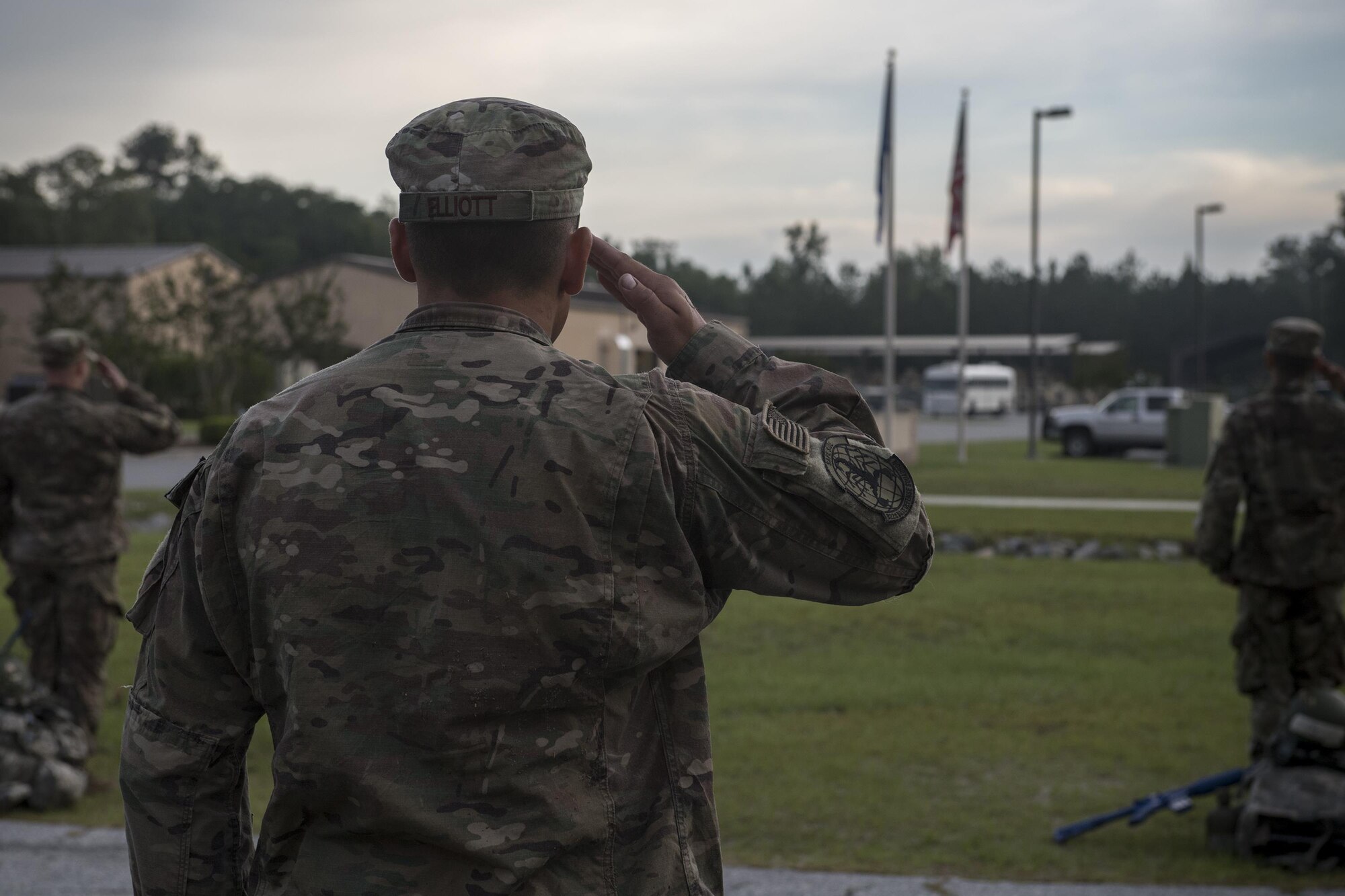 Staff Sgt. Christopher Elliot, 822nd Base Defense Squadron fire team leader, salutes during reveille before completing the last task for an Army Air Assault assessment, May 19, 2017, at Moody Air Force Base, Ga. Twenty-six Airmen attended the assessment which measured candidates’ aptitude in Air Assault operations, completion of equipment layouts, and rappelling. (U.S. Air Force photo by Tech. Sgt. Zachary Wolf)