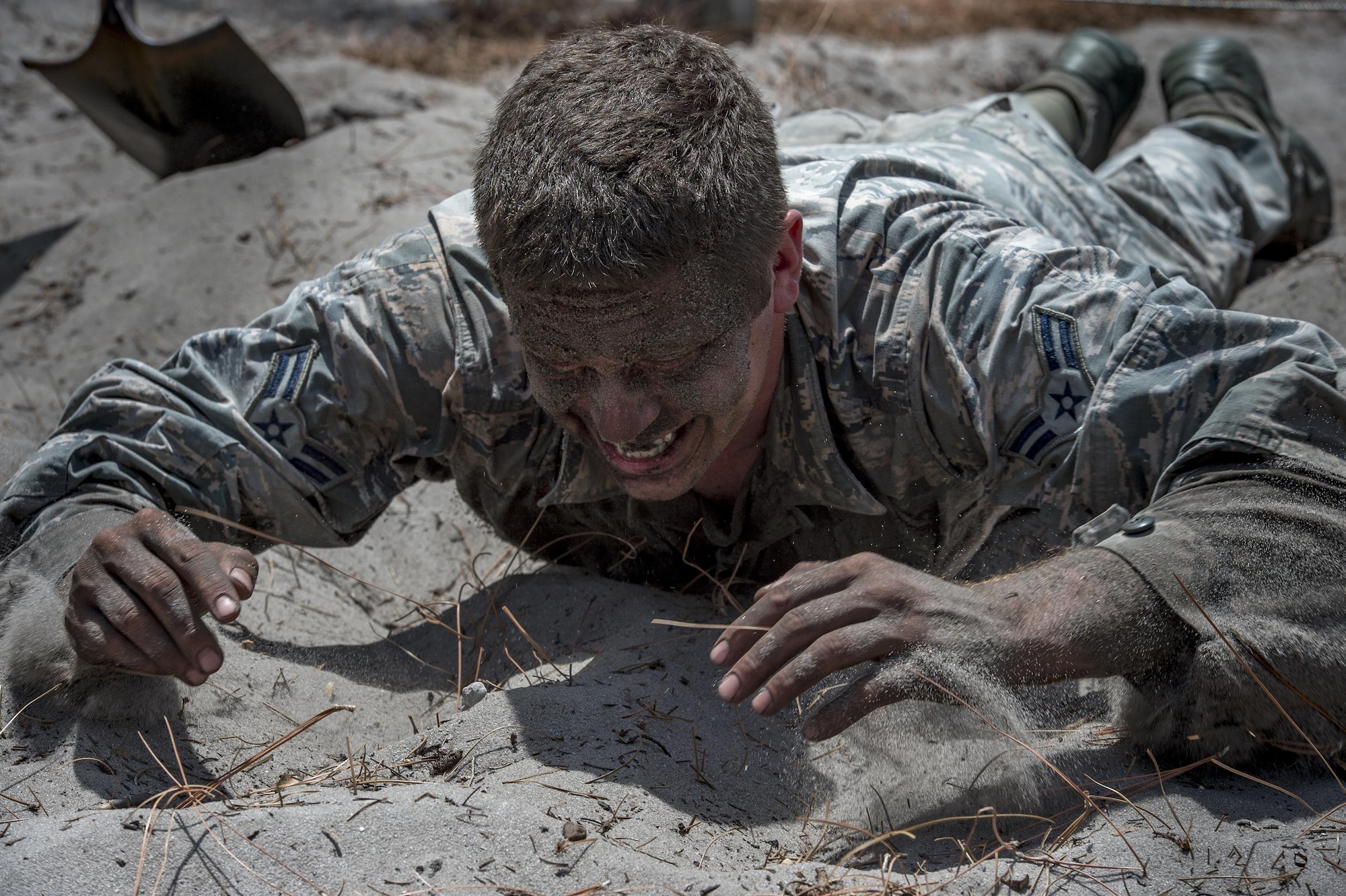 Airman 1st Class Daniel Snider, 23d Wing Public Affairs photojournalist, pulls himself through a low-crawl obstacle during an Army Air Assault assessment, May 18, 2017, at Camp Blanding, Fla. Twenty-six Airmen attended the assessment which measured candidates’ aptitude in Air Assault operations, completion of equipment layouts, and rappelling. (U.S. Air Force photo by Tech. Sgt. Zachary Wolf)