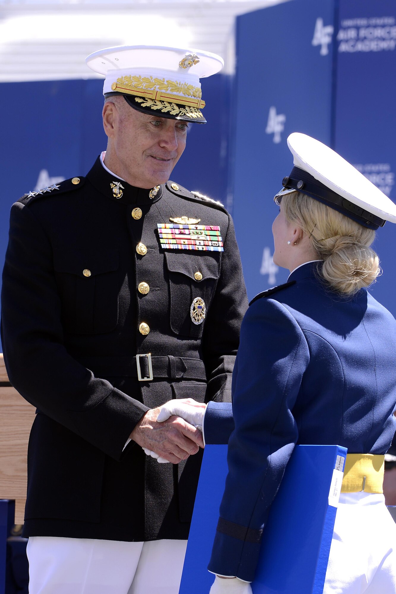 Newly-commissioned 2nd Lt.Darby Germain shakeS hands with Chairman of the Joint Chiefs of Staff Marine Gen. Joseph Dunford during the U.S. Air Force Academy's Class of 2017 Graduation Ceremony at Falcon Stadium, May 24, 2017. (Air Force photo/ Mike Kaplan) 