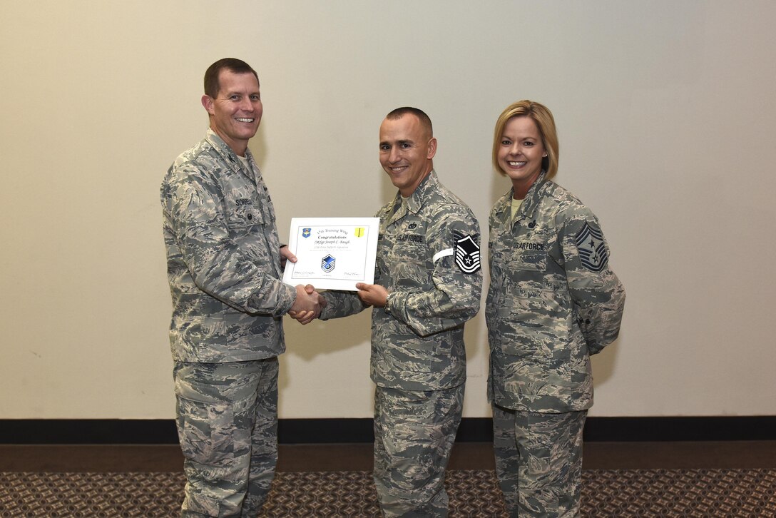 U.S. Air Force Master Sgt. select Joseph Baugh, 17th Force Support Squadron, receives his certificate of selection from Col. Jeffrey Sorrell, 17th Training Wing vice commander, and Chief Master Sergeant Bobbie Riensche, 17th Training Wing command chief, during the Master Sergeant Release Party at the Event Center on Goodfellow Air Force Base, Texas, May 24, 2017.