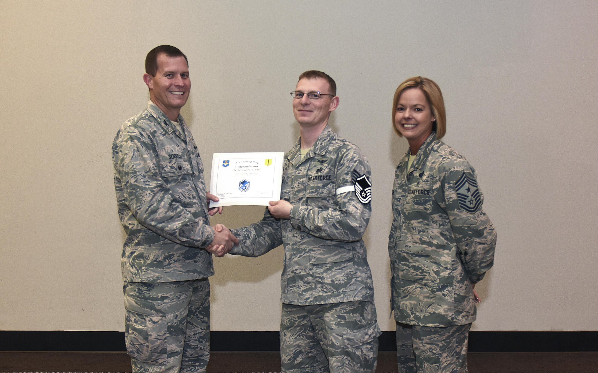 U.S. Air Force Master Sgt. select Andrew Britt, 316th Training Squadron, receives his certificate of selection from Col. Jeffrey Sorrell, 17th Training Wing vice commander, and Chief Master Sergeant Bobbie Riensche, 17th Training Wing command chief, during the Master Sergeant Release Party at the Event Center on Goodfellow Air Force Base, Texas, May 24, 2017.