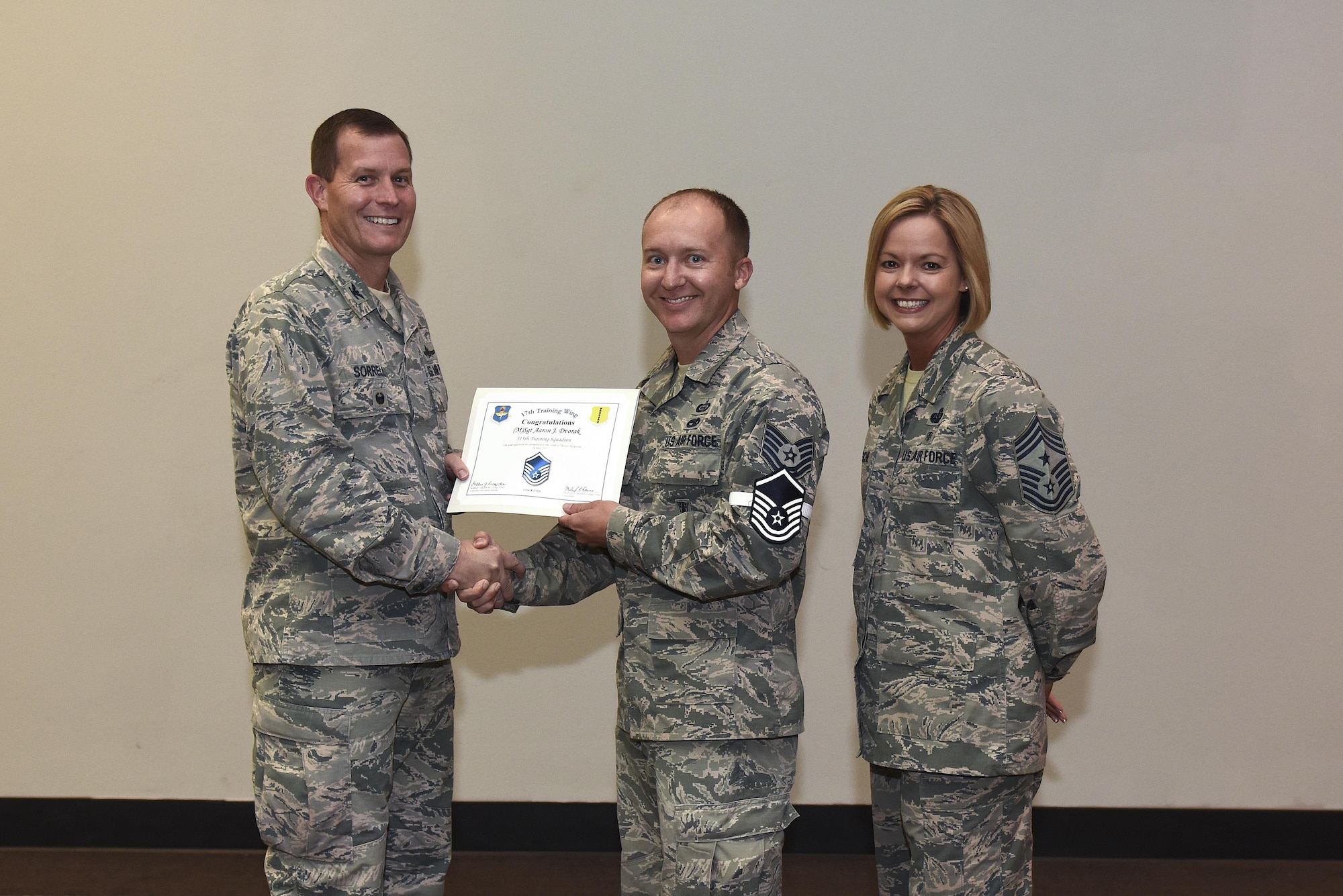 U.S. Air Force Master Sgt. select Aaron Dvorak, 315th Training Squadron, receives his certificate of selection from Col. Jeffrey Sorrell, 17th Training Wing vice commander, and Chief Master Sergeant Bobbie Riensche, 17th Training Wing command chief, during the Master Sergeant Release Party at the Event Center on Goodfellow Air Force Base, Texas, May 24, 2017.