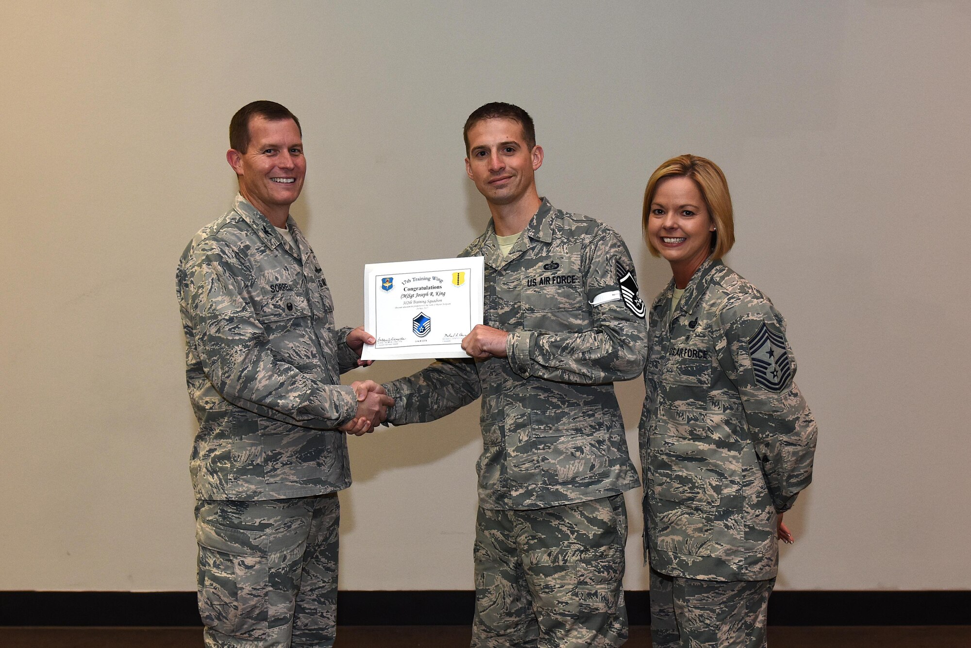 U.S. Air Force Master Sgt. select Joseph King, 312th Training Squadron, receives his certificate of selection from Col. Jeffrey Sorrell, 17th Training Wing vice commander, and Chief Master Sergeant Bobbie Riensche, 17th Training Wing command chief, during the Master Sergeant Release Party at the Event Center on Goodfellow Air Force Base, Texas, May 24, 2017.