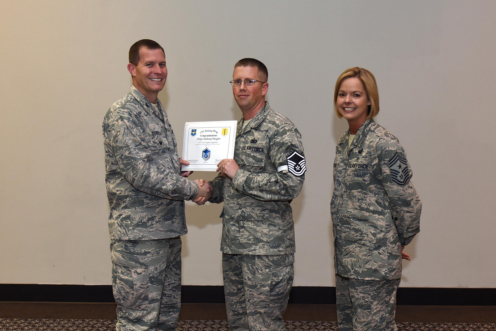 U.S. Air Force Master Sgt. select Nathanael Meagher, 17th Force Support Squadron, receives his certificate of selection from Col. Jeffrey Sorrell, 17th Training Wing vice commander, and Chief Master Sergeant Bobbie Riensche, 17th Training Wing command chief, during the Master Sergeant Release Party at the Event Center on Goodfellow Air Force Base, Texas, May 24, 2017.