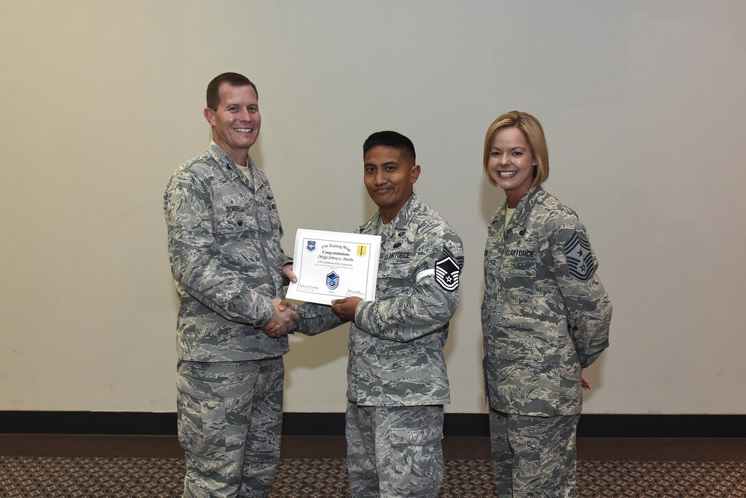 U.S. Air Force Master Sgt. select Johnny Patubo, 17th Communications Squadron, receives his certificate of selection from Col. Jeffrey Sorrell, 17th Training Wing vice commander, and Chief Master Sergeant Bobbie Riensche, 17th Training Wing command chief, during the Master Sergeant Release Party at the Event Center on Goodfellow Air Force Base, Texas, May 24, 2017.