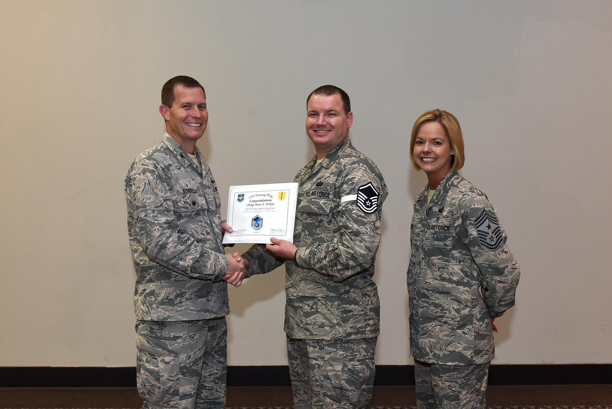 U.S. Air Force Master Sgt. select Bruce Perkins, 17th Training Support Squadron, receives his certificate of selection from Col. Jeffrey Sorrell, 17th Training Wing vice commander, and Chief Master Sergeant Bobbie Riensche, 17th Training Wing command chief, during the Master Sergeant Release Party at the Event Center on Goodfellow Air Force Base, Texas, May 24, 2017.