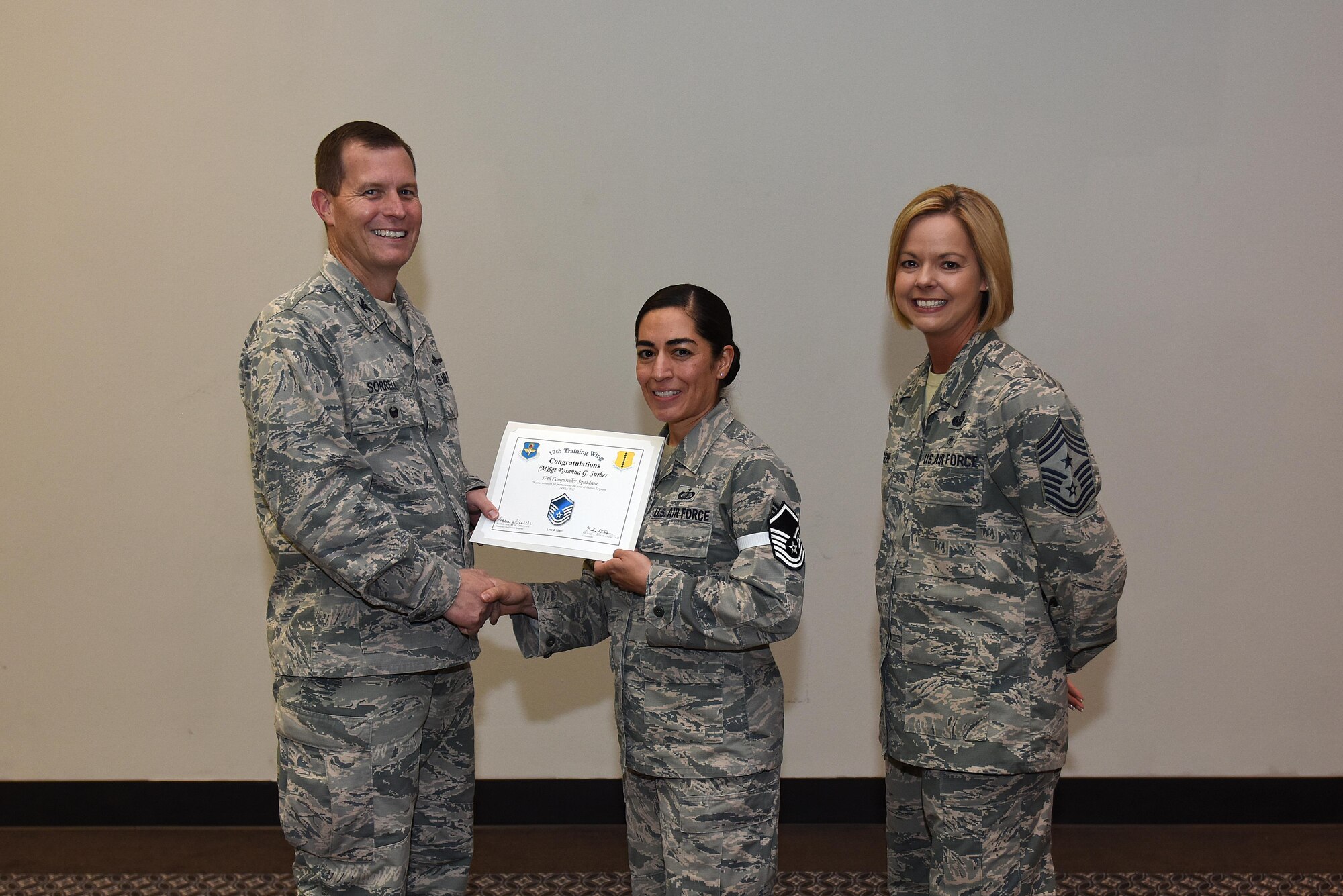 U.S. Air Force Master Sgt. select Rosanna Surber, 17th Comptroller Squadron, receives her certificate of selection from Col. Jeffrey Sorrell, 17th Training Wing vice commander, and Chief Master Sergeant Bobbie Riensche, 17th Training Wing command chief, during the Master Sergeant Release Party at the Event Center on Goodfellow Air Force Base, Texas, May 24, 2017.