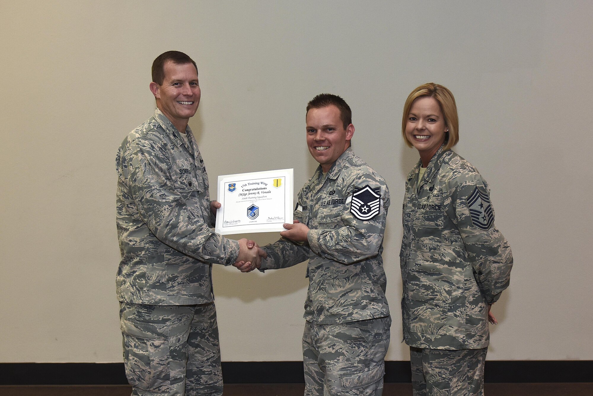 U.S. Air Force Master Sgt. select Jeremy Vonada, 316th Training Squadron, receives his certificate of selection from Col. Jeffrey Sorrell, 17th Training Wing Vice Commander, and Chief Master Sergeant Bobbie Riensche, 17th Training Wing Command Chief, during the Master Sergeant Release Party at the Event Center on Goodfellow Air Force Base, Texas, May 24, 2017. (U.S. Air Force photo by Airman 1st Class Caelynn Ferguson/ Released)