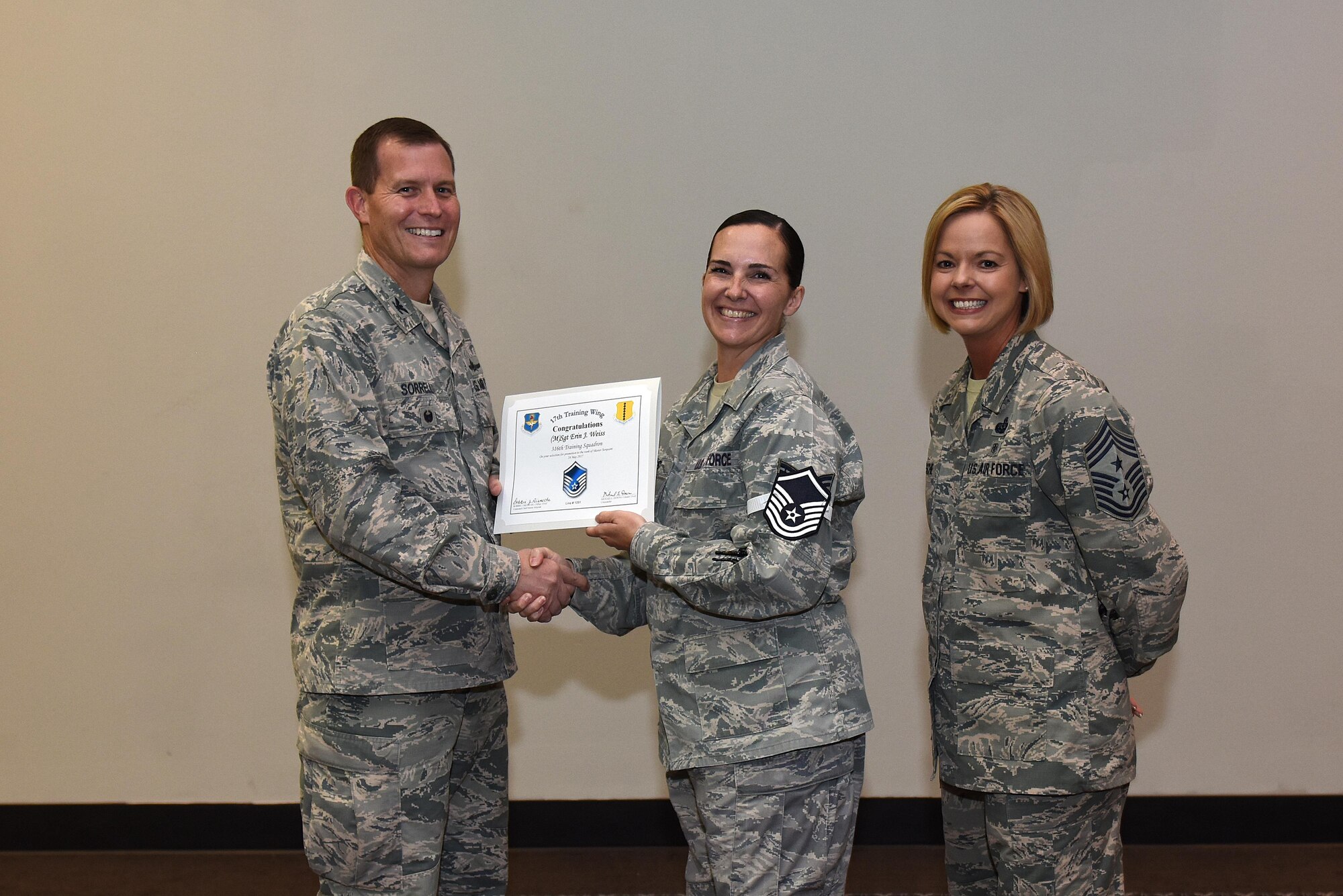U.S. Air Force Master Sgt. select Erin Weiss, 316th Training Squadron, receives her certificate of selection from Col. Jeffrey Sorrell, 17th Training Wing vice commander, and Chief Master Sergeant Bobbie Riensche, 17th Training Wing command chief, during the Master Sergeant Release Party at the Event Center on Goodfellow Air Force Base, Texas, May 24, 2017.
