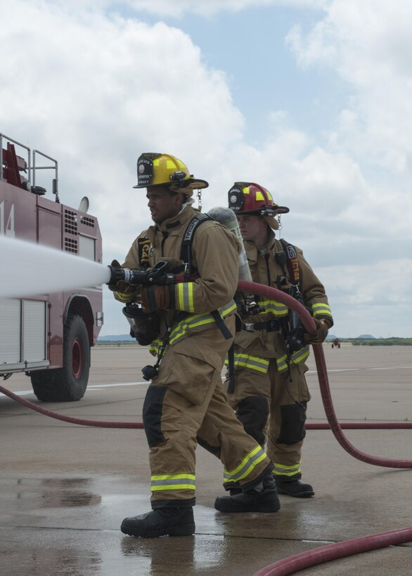 From left to right, U.S. Air Force Senior Airman Clements Dorsey, 7th Civil Engineer Squadron Fire Prevention craftsman, and Staff Sgt. Jared Weeks 7th Civil Engineering Squadron Fire Prevention crew chief, participate in a group-training exercise at Dyess Air Force Base, Texas, May 22, 2017. In addition to using water to extinguish fires, firefighters may use foam to prevent the fire from getting oxygen, resulting in the suppression of the fire. (U.S. Air Force photo by Airman 1st Class Katherine Miller)