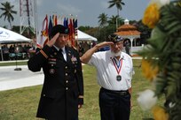 Col. Michael T. Harvey, Fort Buchanan Garrison Commander, and Javier Morales salute as taps is played during the Memorial Day wreath-laying ceremony at Soldiers Plaza, on Fort Buchanan, May 24.