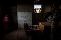 (Front) A Royal Marine Commando watches a coalition member inside of a building at Florence, Ariz., during Angel Thunder 2017, May 9, 2017. Angel Thunder is a two-week, Air Combat Command-sponsored, joint certified and accredited personnel recovery exercise focused on search and rescue. The exercise is designed to provide training for personnel recovery assets using a variety of scenarios to simulate deployment conditions and contingencies. (U.S. Air Force photo by Staff Sgt. Corey Hook)