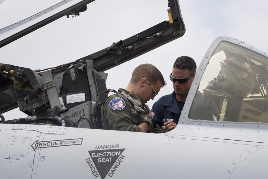 Staff Sgt. Christopher Fisher, A-10 East Heritage Team crew chief, helps Capt. Joseph Morrin, A-10 East Heritage Team pilot, fasten his harness before the heritage flight, May 21, 2017, at Seymour Johnson Air Force Base, N.C. The heritage flight is performed by multiple aircraft at events throughout the United States. Originally established in 1997, the heritage flight showcases the past, present and future generations of aircraft to bolster recruiting. (U.S. Air Force photo by Staff Sgt. Eric Summers Jr.)