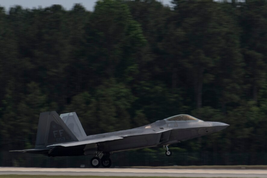 A F-22 Raptor lands after performing a heritage flight during the Wings Over Wayne Airshow 2017, May, 21, 2017, at Seymour Johnson, N.C. The heritage flight is performed by multiple aircraft at events throughout the United States. Originally established in 1997, the heritage flight showcases the past, present and future generations of aircraft to bolster recruiting. (U.S. Air Force photo by Staff Sgt. Eric Summers Jr.)