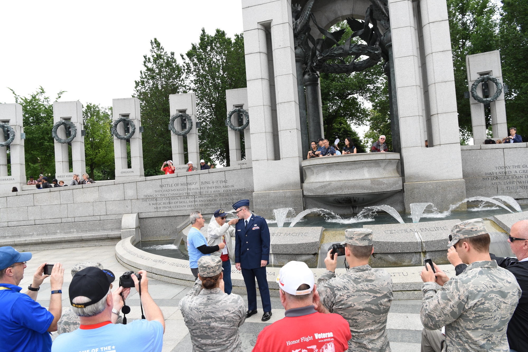 First Lt. Nicholas Lundin, 480th Intelligence, Reconnaissance and Surveillance Wing chief of current operations, has his ranks pinned on by his dad Michael Lundin and grandfather Ray Lundin during his promotion ceremony May 24, 2017 at the World War II memorial in Washington D.C. A crowd of veterans and guardians watched the ceremony and came up afterward to congratulation the new captain. (U.S. Air Force photo by Tech. Sgt. Darnell T. Cannady)