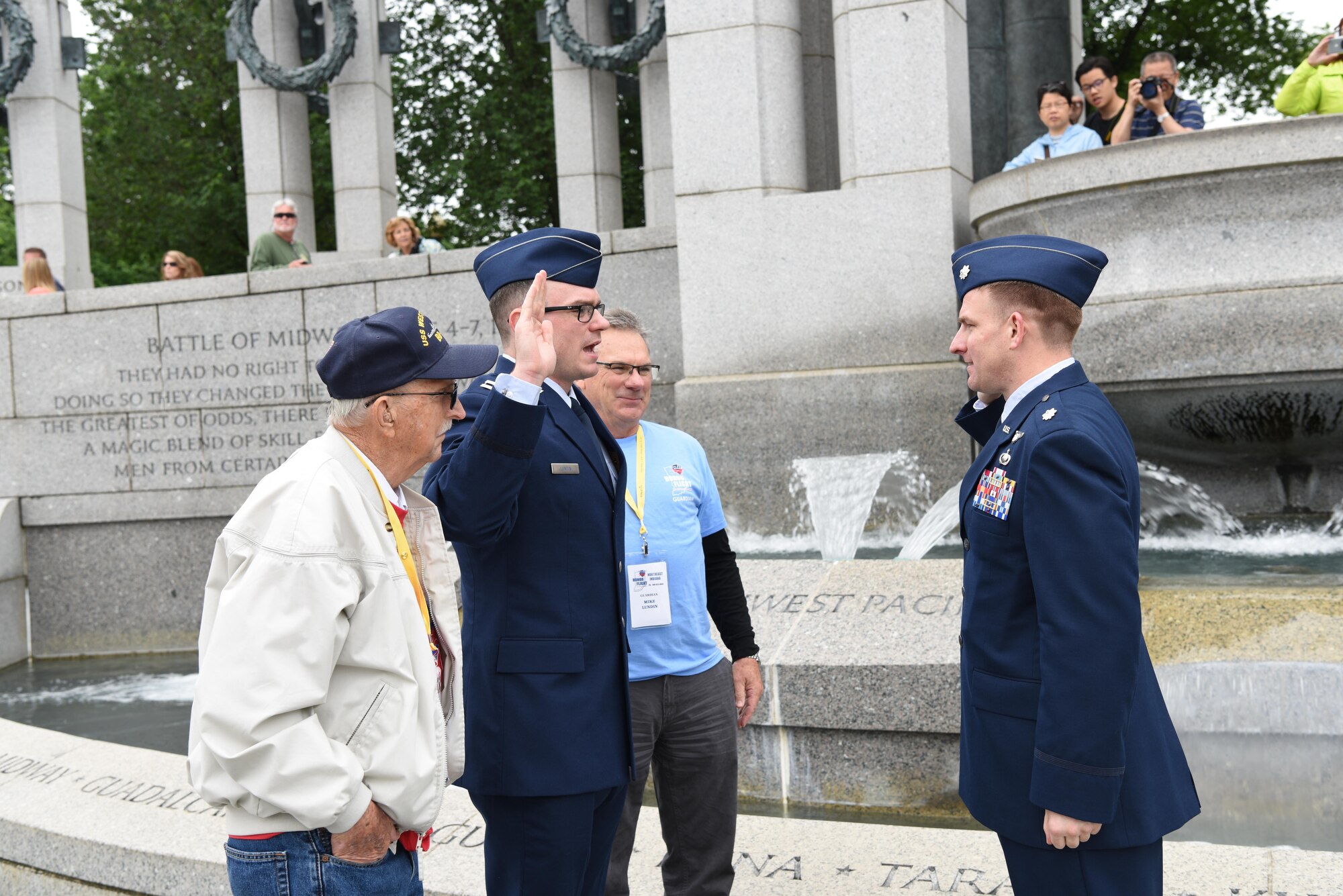 First Lt. Nicholas Lundin, 480th Intelligence, Reconnaissance and Surveillance Wing chief of current operations, stands between his dad Michael Lundin and grandfather Ray Lundin while saying the oath of enlistment administered by Lt. Col. Brian Webster, presiding officer, May 24, 2017 at the World War II memorial in Washington D.C. Underneath the Pacific portion of the World War II monument, 1st Lt. Nicholas Lundin’s new rank was pinned on by his father and grandfather. (U.S. Air Force photo by Tech. Sgt. Darnell T. Cannady)