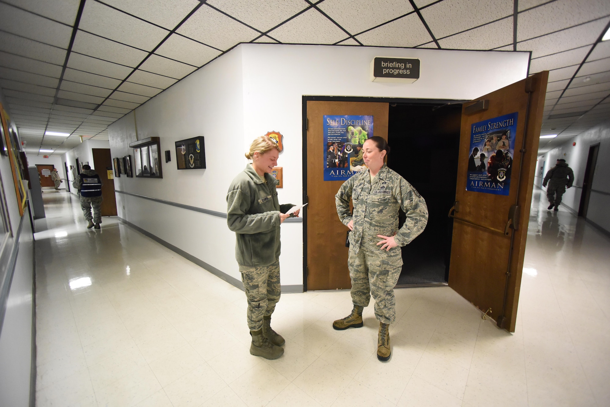 Airman Jordyn Sorber, 193rd Special Operations Wing, operations personalist, reviews the exercise injection card she receives from Master Sgt. Jamie Wolf, 193rd SOW, installation emergency management manager, as wing inspection team members disperse to monitor the halls of the building. The injection card explains the scenario that is occurring during the active shooter exercise on base, May 25, 2017. (U.S. Air National Guard photo by Tech. Sgt. Claire Behney/Released)
